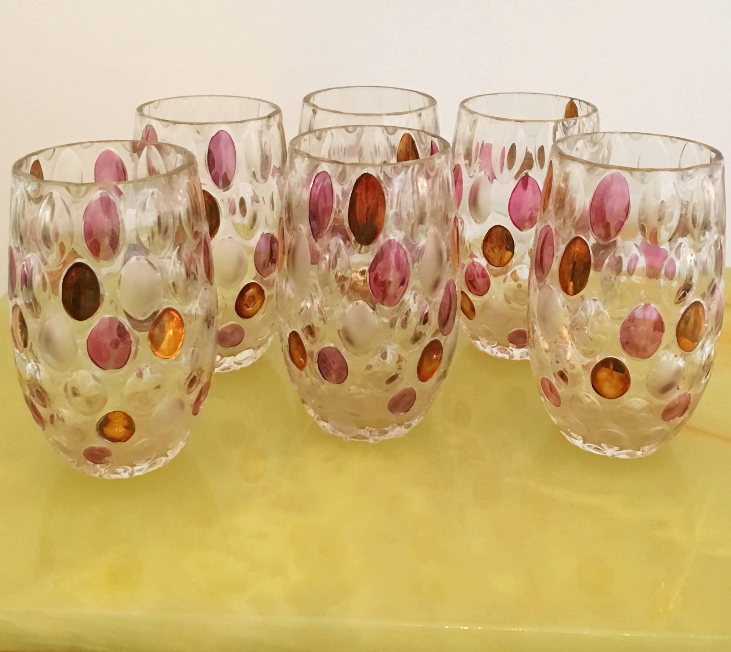 The set of molded drink glasses in clear glass with oval dot decoration randomly colored in gold/copper, amethyst and frosted glazes. Produced by the Czech glass company Borske Sklo National Corporation, a union of the leading national glass