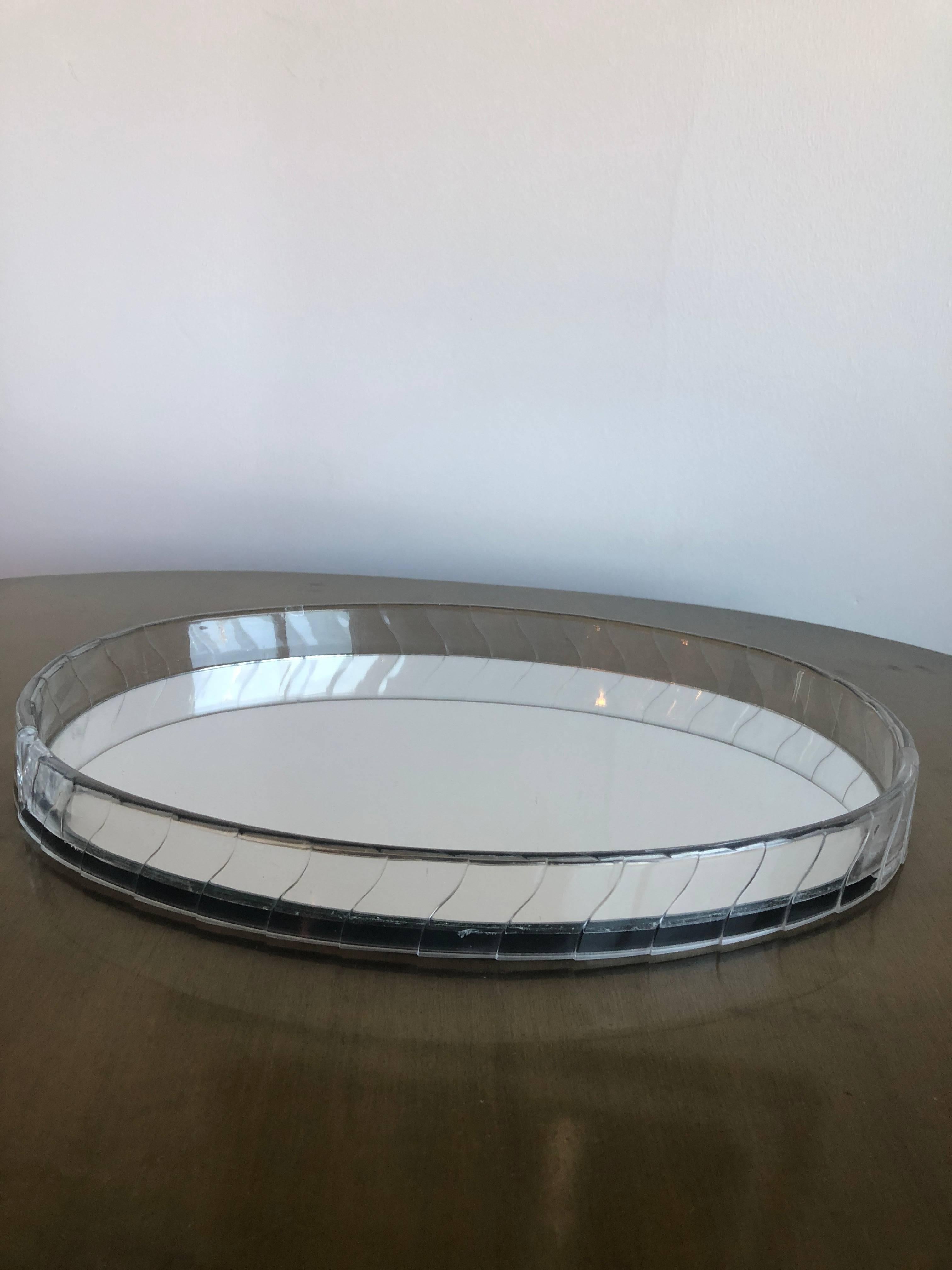 Offered is an Art Deco / Hollywood Regency Glam oval Lucite mirrored decorative vanity / drinks tray. This stunning shimmering oval tray captures the style of Hollywood's Golden Years. The tray is formed out of two pieces of curved acrylic cast to