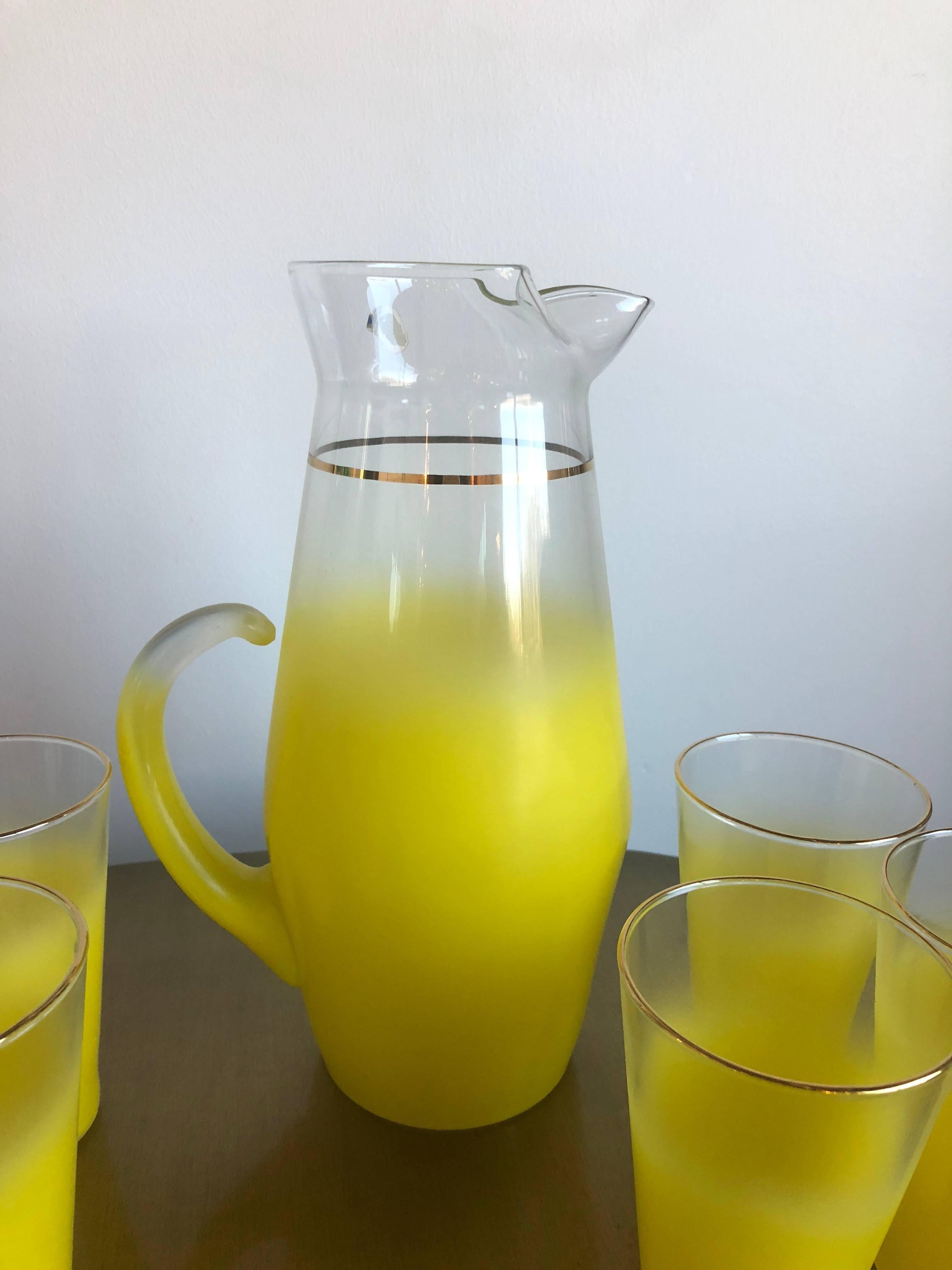 This cheerful beverage set produced by the West Virginia Glass Speciality Company between 1958 and 1974 features sprayed on yellow "Gala" pattern decoration and gold banding. Comprising a large pitcher (which retains the original factory