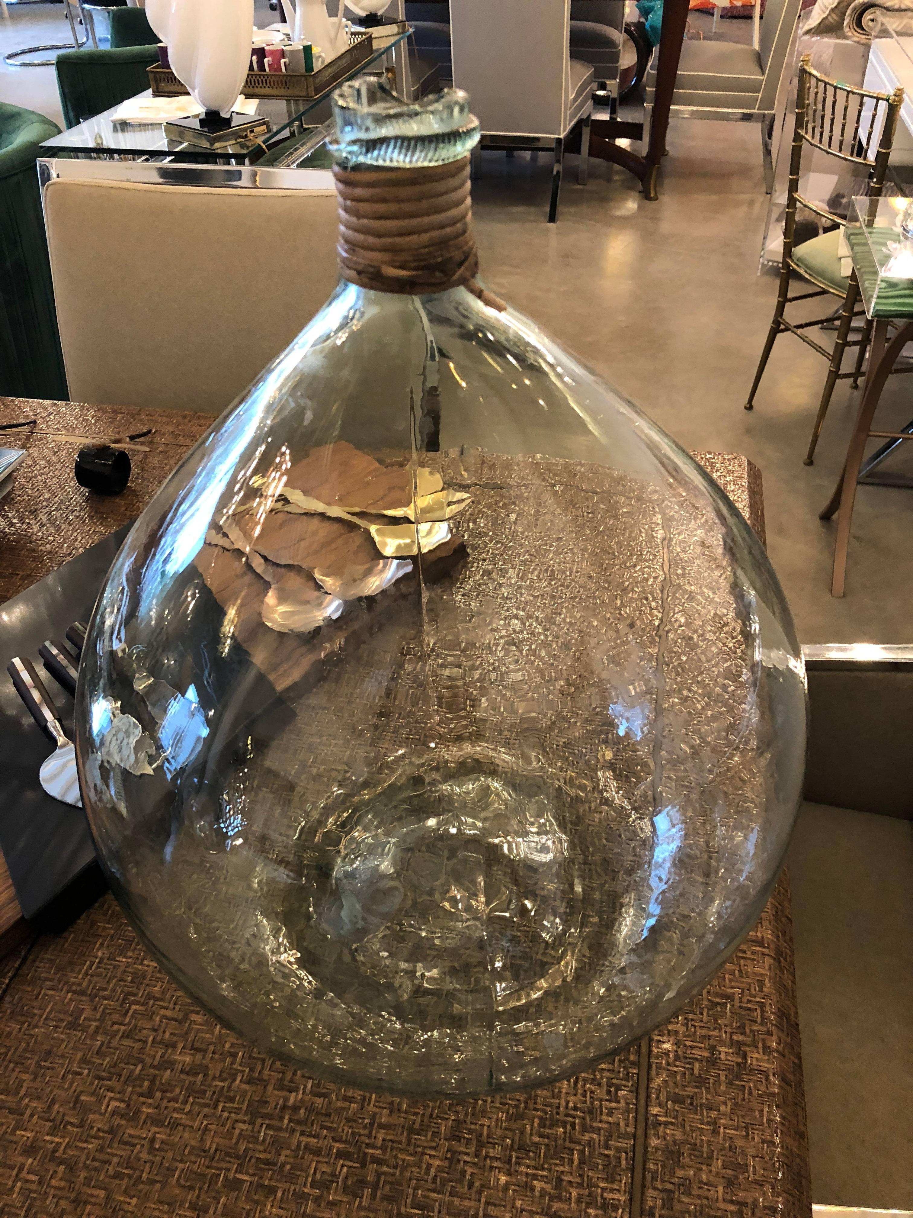Offered is a mid century modern Argentine handblown aqua / light green glass demijohn wine jug.  The large pear shaped handblown wine storage vessel has an everted lip and cane wrapped neck.