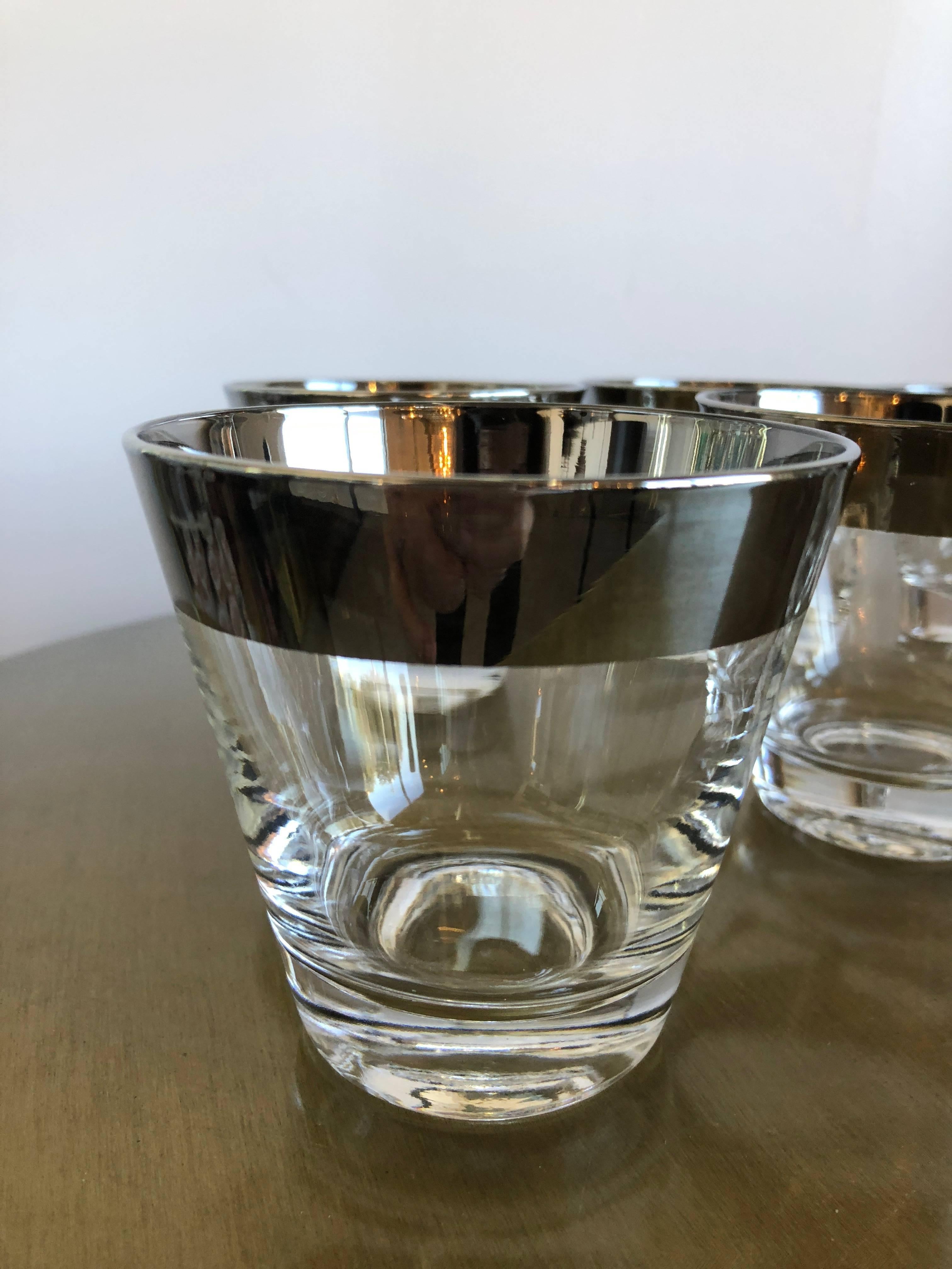 Offered is a pristine mid century modern set of seven Dorothy Thorpe silver overlay whiskey cocktail glasses.

Dorothy Thorpe glassware was a chic staple of every mid-century modern wet bar, particularly her festive Roly Poly silver-banded tumblers.