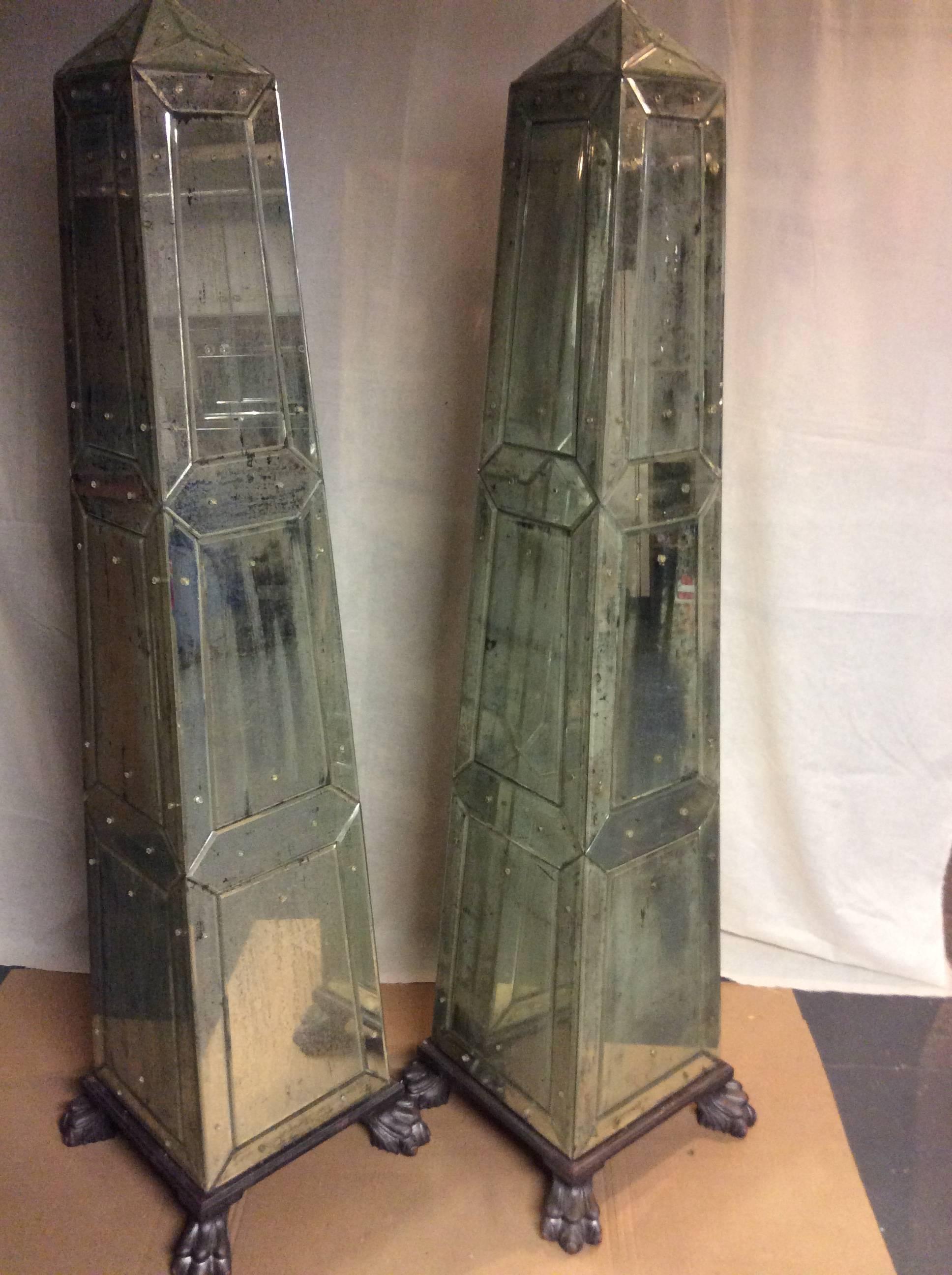 Pair of antique mirrored Obelisks in the style of Serge Roche.
Each in excellent condition, with beveled antique glass panels, resting on silvered paw feet.