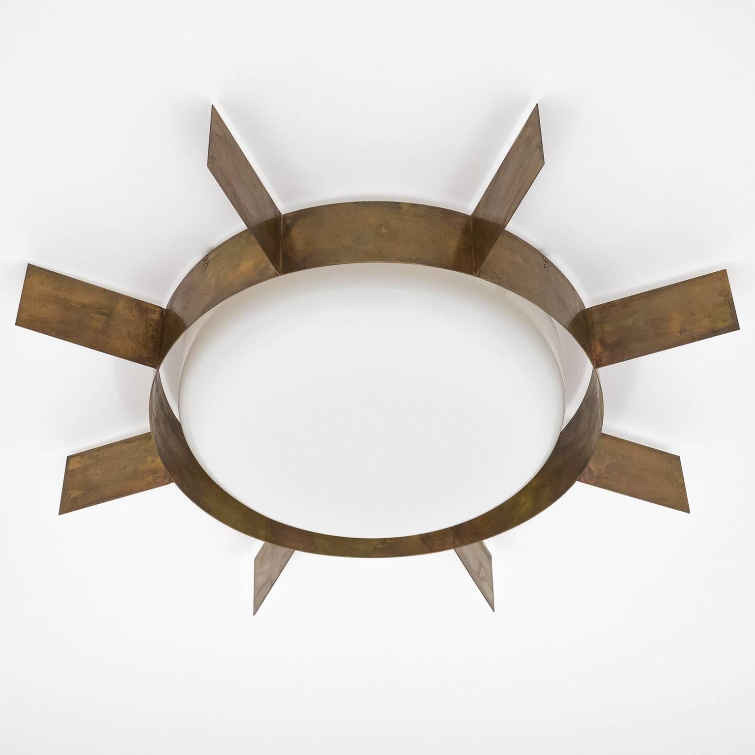 Iconic brass sunburst ceiling lights designed by Gio Ponti and manufactured by Arredoluce in Italy, 1950s. The hardware is entirely of untreated brass which has developed a beautiful patina over the decades. Under the large white Perspex diffuser