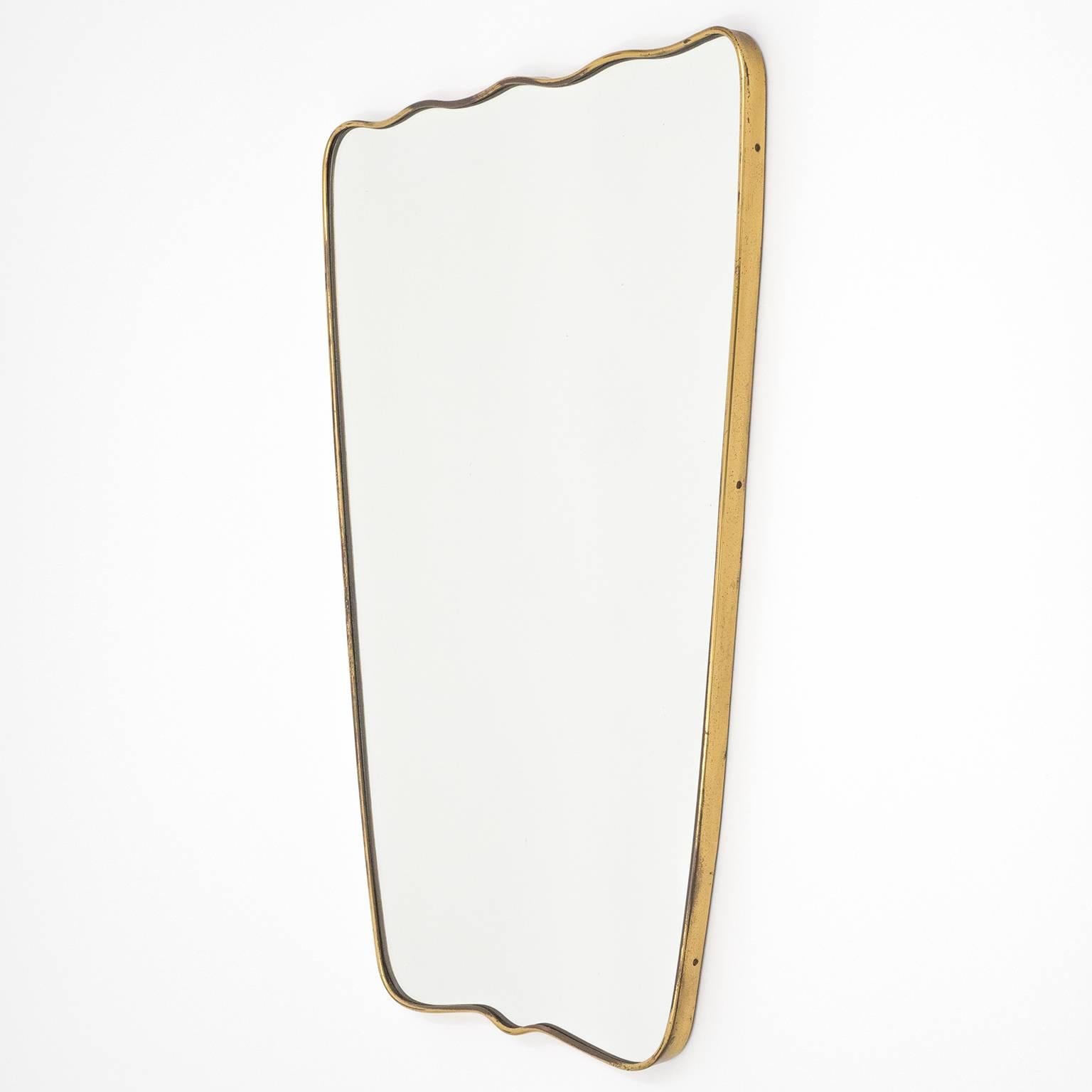 Very unique Gio Ponti style brass mirror from Italy, 1950s. The undulating top and bottom give this mirror a very special characteristic. Lovely original condition with a nice patina on the brass and a few specks in the mirror.