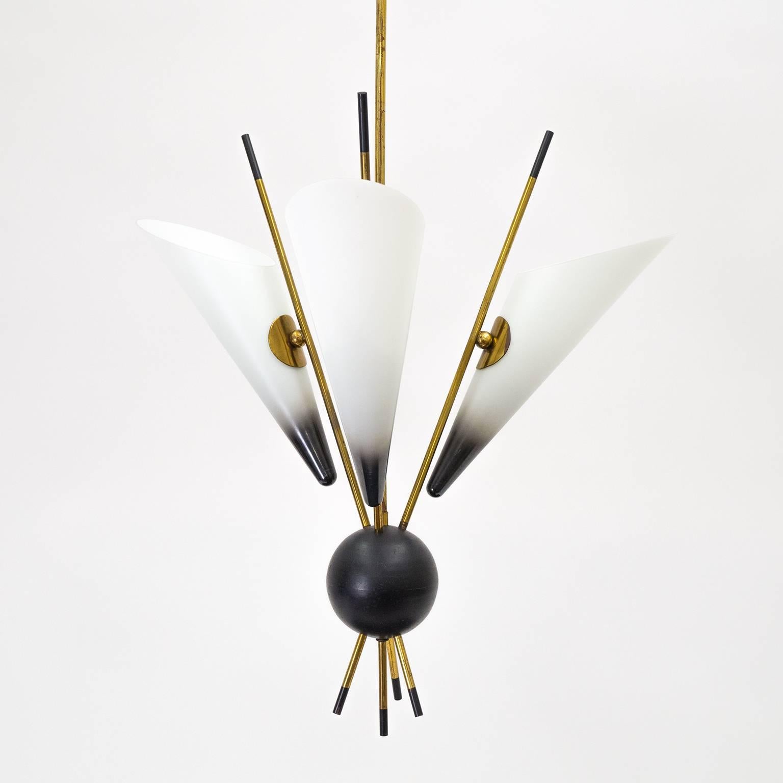 Excellent modernist Italian chandelier from the 1950s. A very unique variation on the Sputnik motif with three large glass cones - which are cased, satinated and partially enameled. Very good condition with some age-related patina on the brass