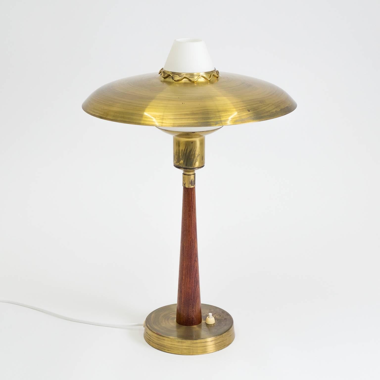 Lovely midcentury table or desk lamp from Sweden in a combination of brass, teak and satin glass. The weighted brass base holds a solid teak stem which culminates in a cased satin glass diffuser, atop of which rests a large brass shade with a
