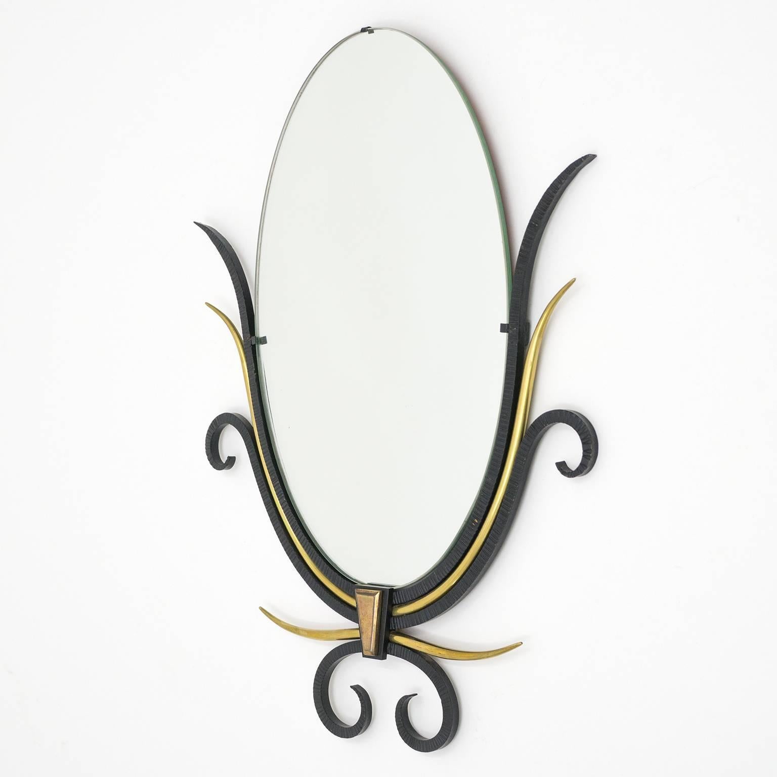 Wonderful lyrical French Art Deco mirrors in the style of Gilbert Poillerat. Very nice combination of blackened wrought iron with smooth brass elements. Good original condition with a light patina to the brass and wrought iron and some age-related