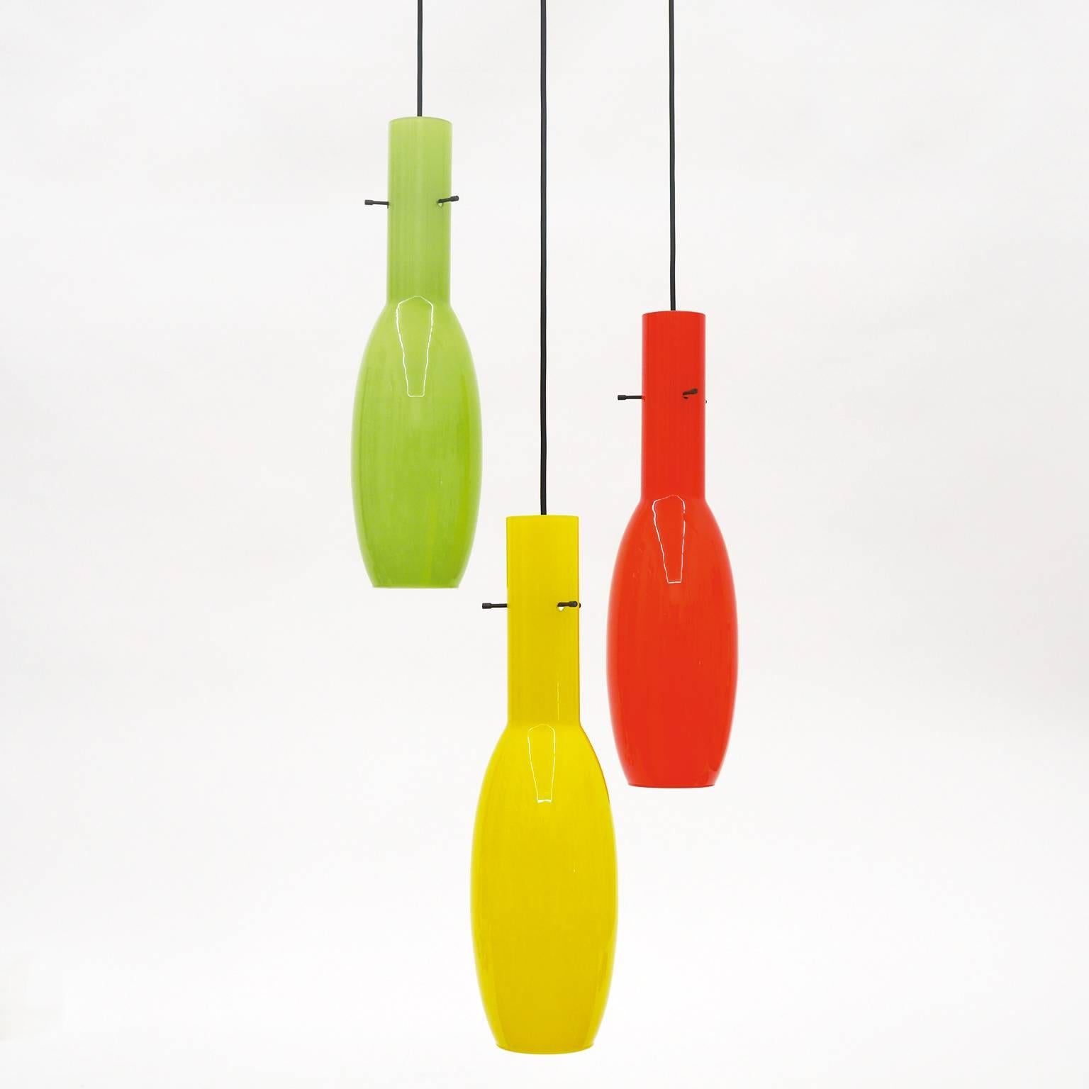 Colorful cascading glass chandelier by Stilnovo, circa 1960. Three large cased glass pendants (each 19inches/48cm long) are suspended from a brass and lacquered aluminum ceiling plate. The height listed below is as pictured in the first image and