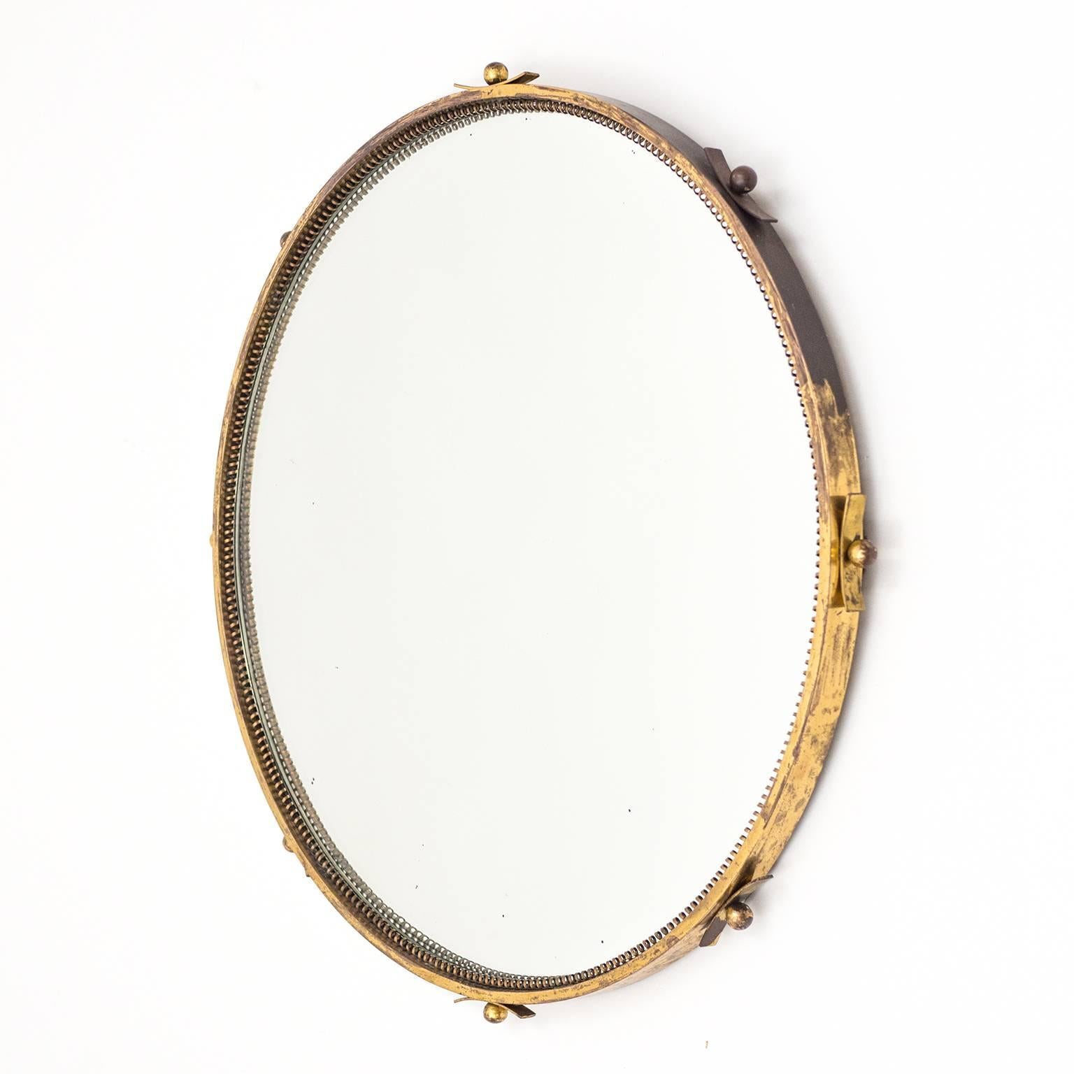 Lovely round brass Art Deco mirror from the 1930s. A thick solid brass rim (0.2inches / 5 mm) with brass details on the outside and a continuous brass 