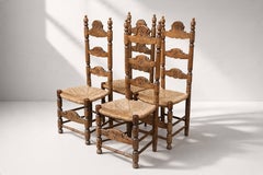 Juego de seis sillas de comedor españolas con respaldo de escalera, de roble tallado y junco, década de los 50