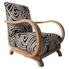 Fauteuil Art déco aux accoudoirs courbés, bois blanchi, revêtement à motifs graphiques, années 1930