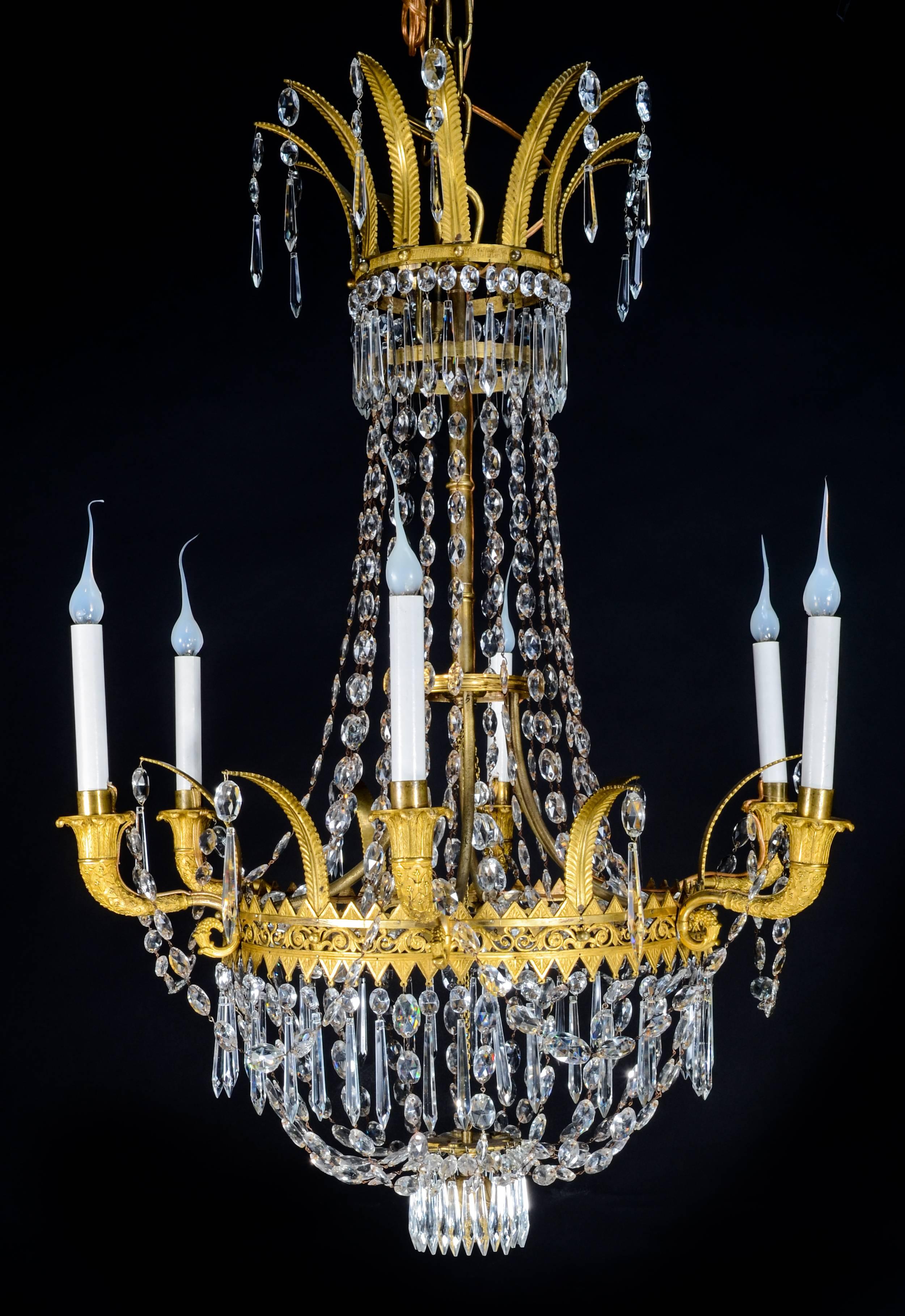 A superb antique Empire gilt bronze and cut crystal multi light chandelier of exquisite detail embellished with cut crystal prisms and chains, circa 1810.