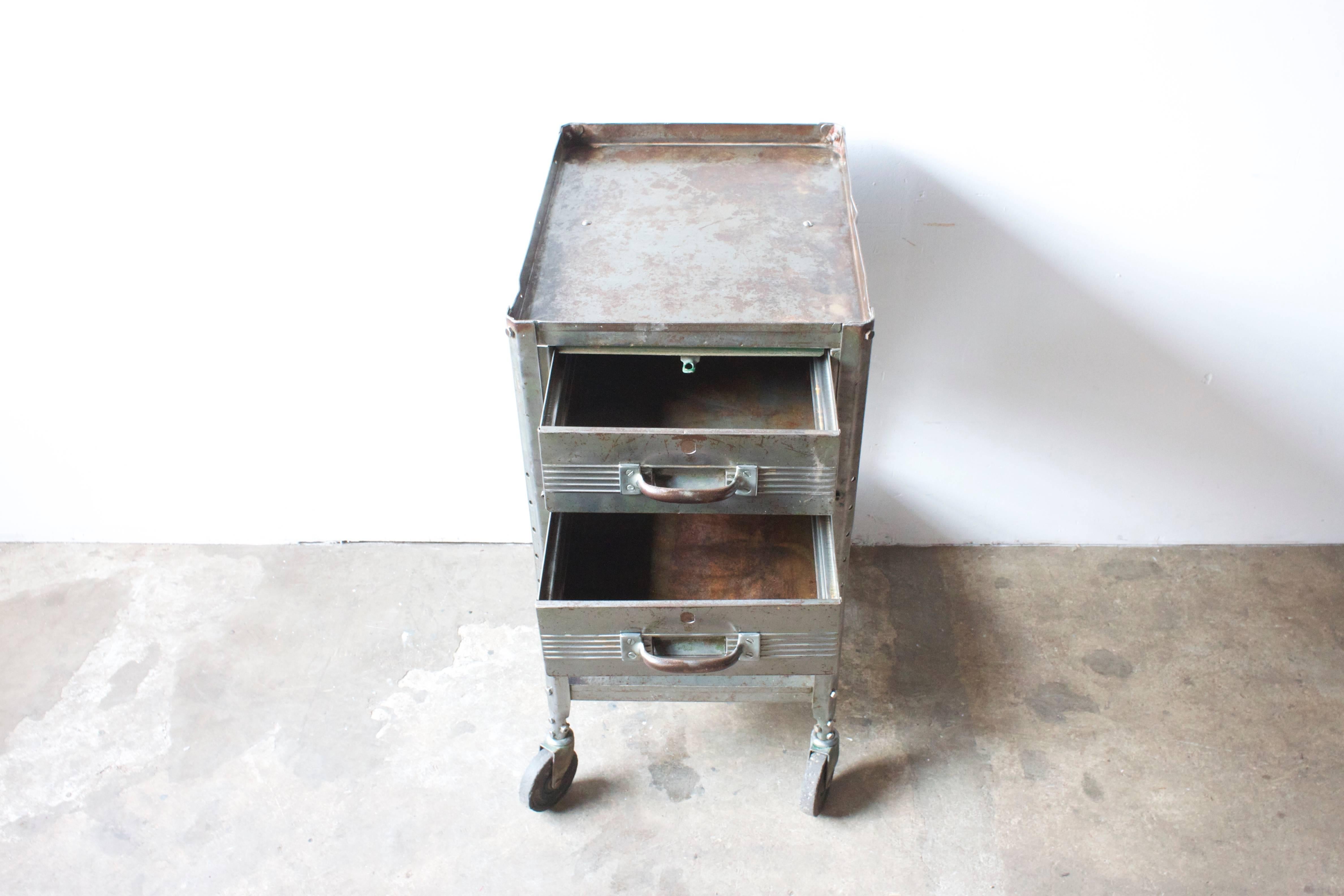 Industrial metal rolling cart. Two drawers. One shelf.