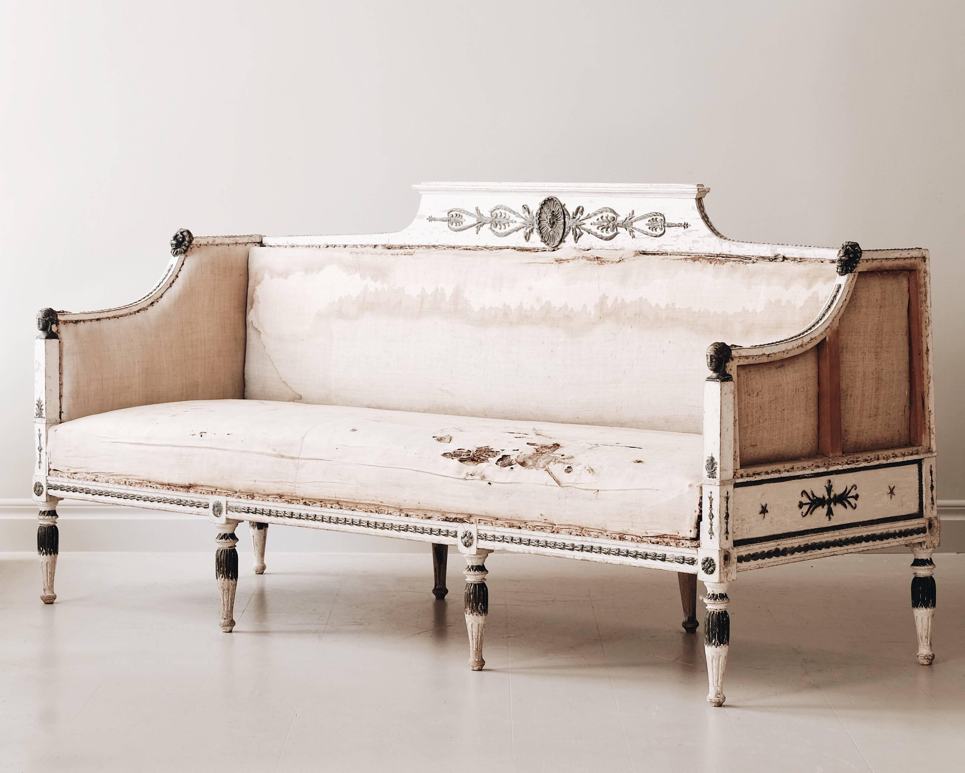 Fine 19th century late Gustavian sofa inspired by the Roman Empire and ancient Egypt. The sofa has its original padding left and is in original color with faux oxidized copper painted to the carvings, lion heads and female heads on the armrests.