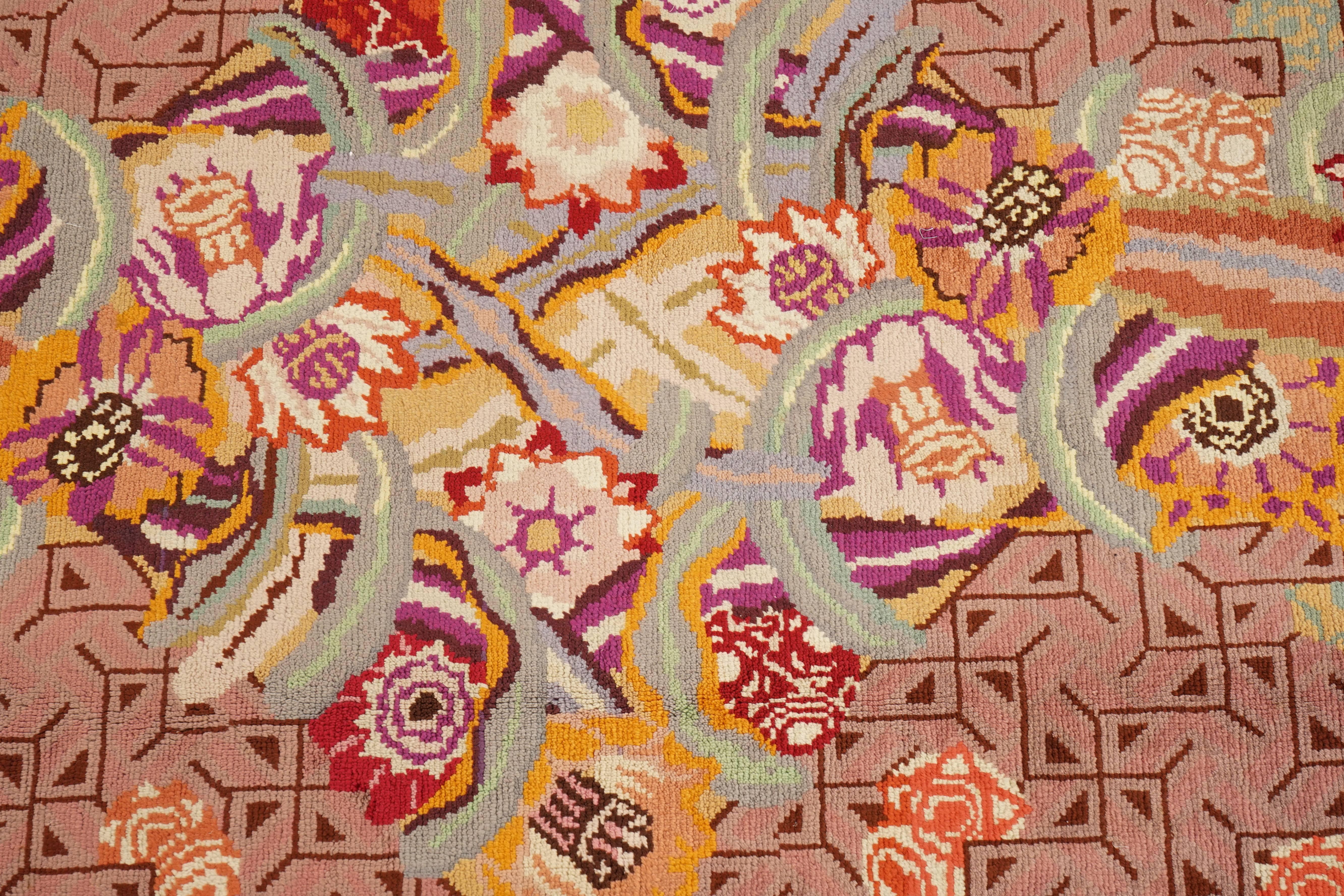 An Art Deco rug designed by Jules Coudyser (1867-1931), the pink field with a geometric motif overlaid by voluptuous flowers with striped upper and lower borders in red and green.
Jules Coudyser had various rugs and tapestries exposed in the most