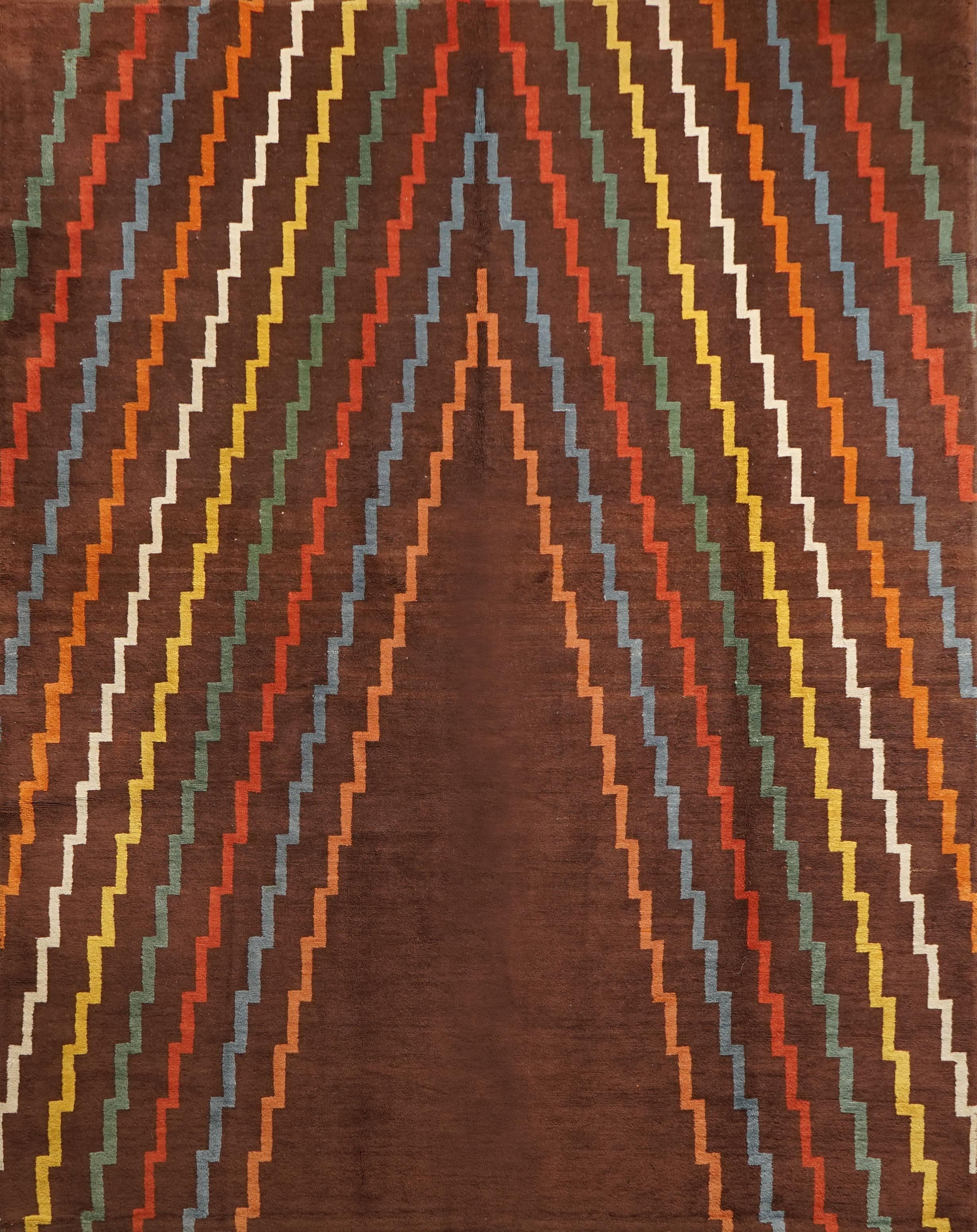 This Art Deco rug was made in the 1940s by an unknown artist. It is a handwoven carpet in thick wool. The geometrical lines are in beautiful vivid colors on a deep brown background.