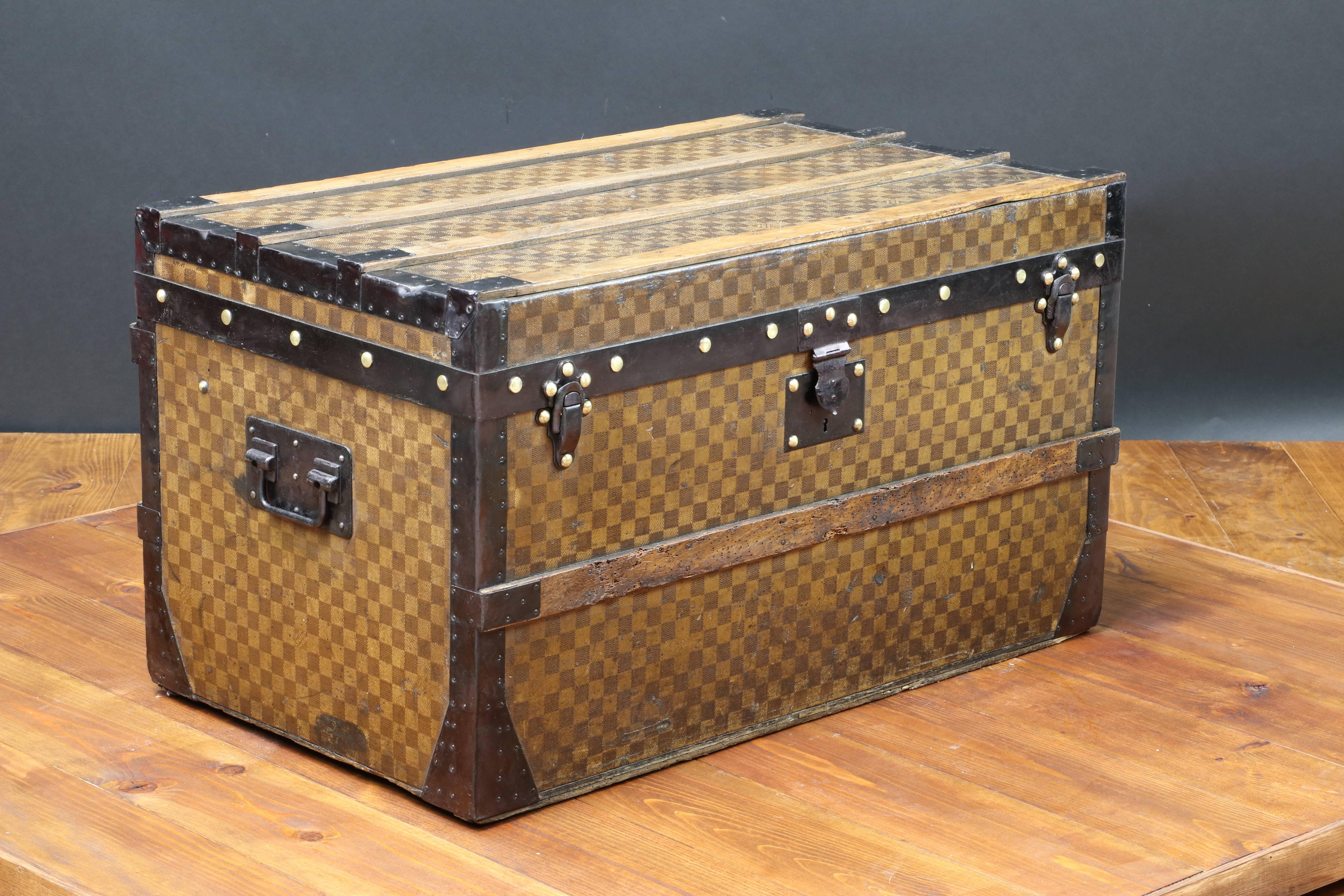 Very elegant Louis Vuitton trunk, 
black steel trim and side handles. 
Metal locks. 
Old tags. Wood slats. Original beige lining interior, Louis Vuitton tag.
The trunk is just cleaned. 
All parts in steel are original. 
The lock is in steel
