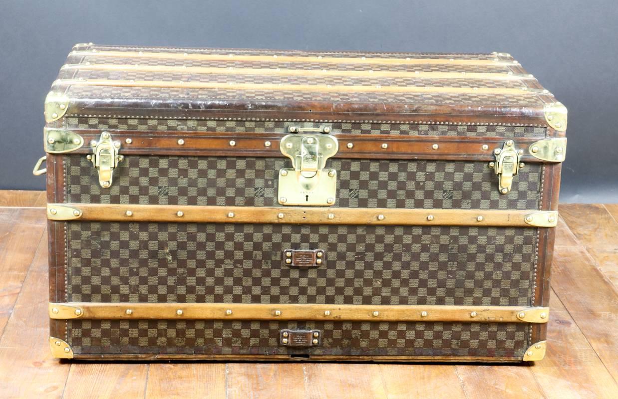 Louis Vuitton Damier trunk. 

Two original trays. 

The trunk was cleaned with touch of restauration. 

Massif brass lock, hasp and handels. 

Natural leather border. 

Size in cm: 90 cm de wide X 50 height X 50 cm deep. 
Malle courrier