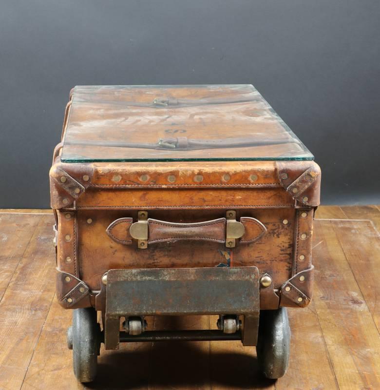 Leather trunk, English origin, attached to an old wagon of handler of the railway station of Lausanne in switzerland.

Supplied with a protective glass.

Size of the suitcase alone 93 cm long x 30 cm high x 53 cm deep.

Size all include 125