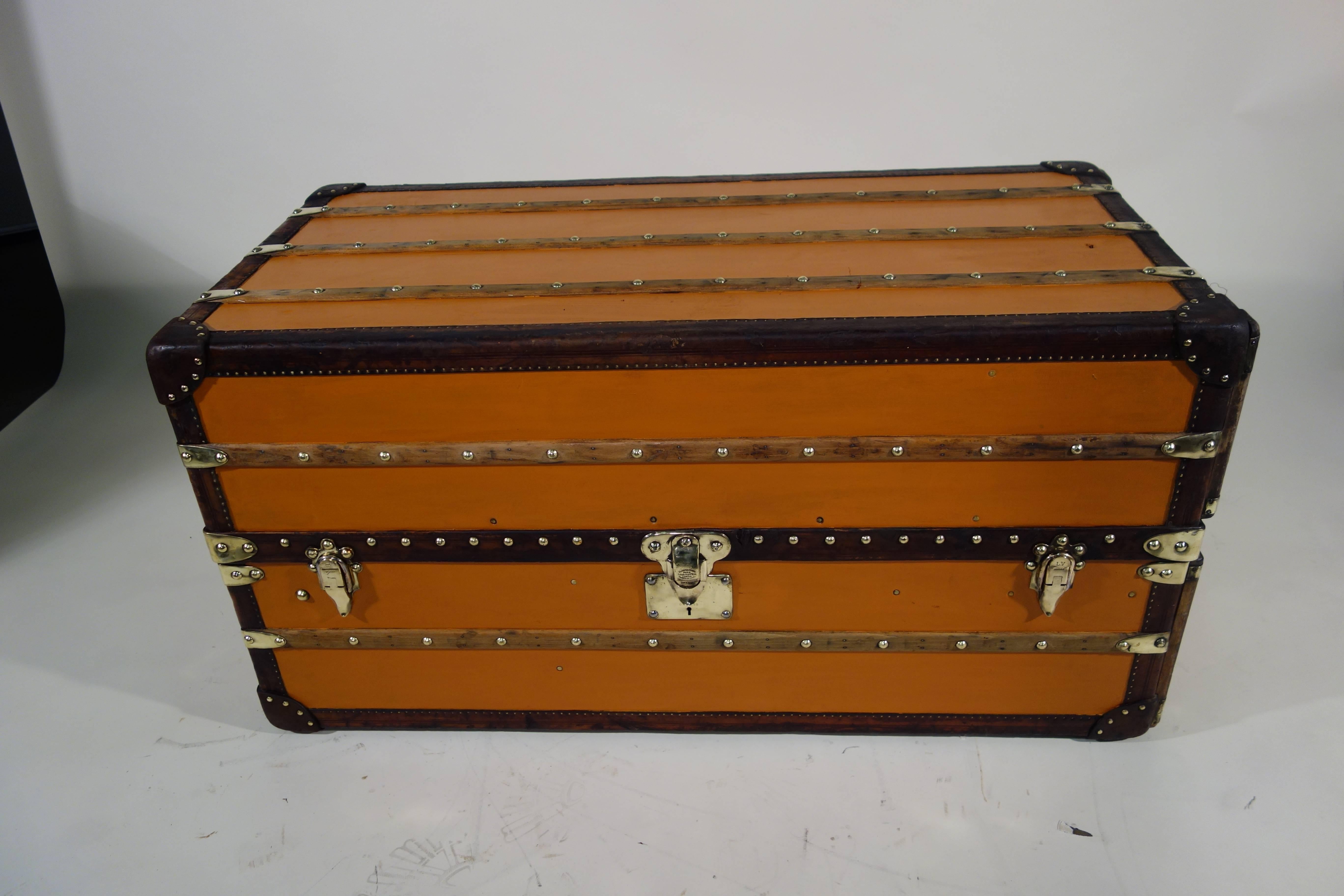 Louis Vuitton wardrobe trunk in orange vuitonitte.

Orange canvas (redone).

Lock in massif brass.

Real leather corners (not lozine).

Six trays, with new handle in leather.

One original suitcase for shoes.

Hangers for men and