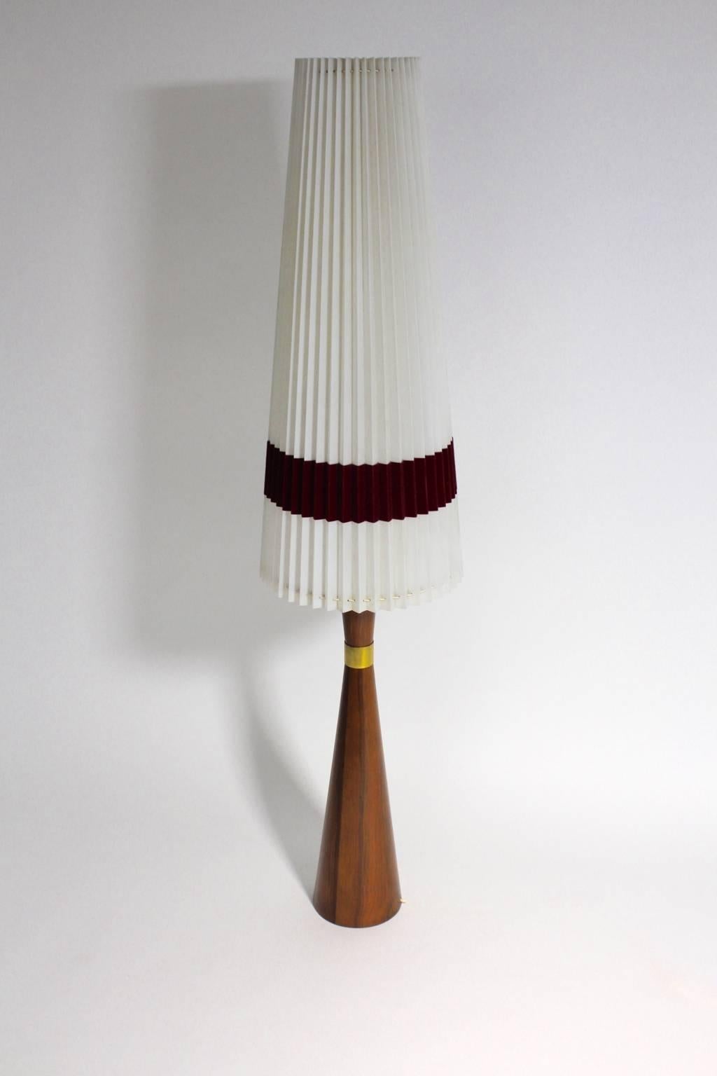 Scandinavian modern vintage teak table or floor lamp with a beautiful teak veneer, which is decorated with a brass details.
The original shade is made of nylon with a Bordeaux velvet ribbon along the bottom.