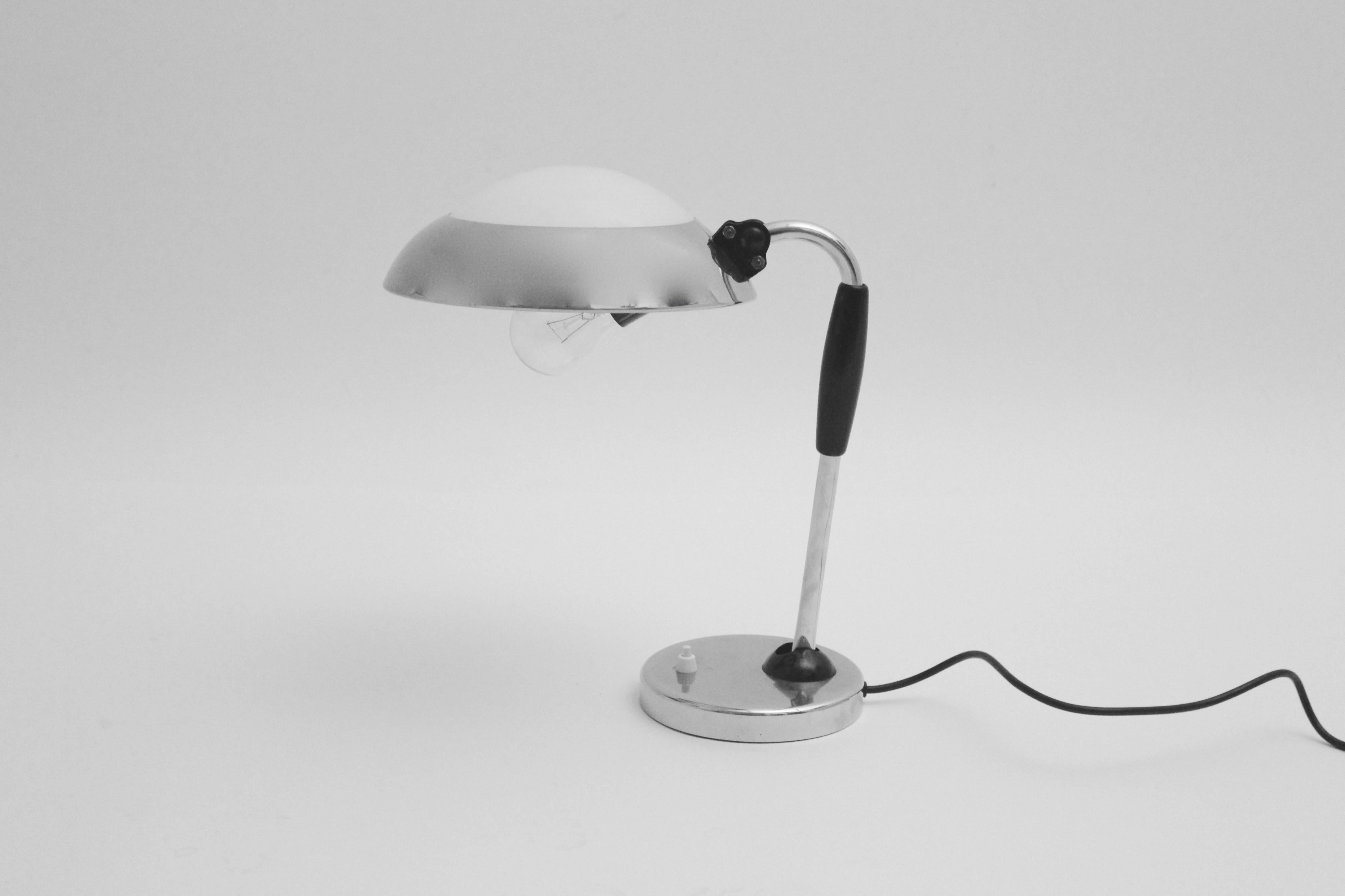 Bauhaus vintage metal desk lamp or table lamp attributed to Christian Dell, Germany, 1930s.
While the base of the table lamp shows chromed metal, the shade is made of chromed metal, white plexiglass and black lacquered wooden handle.
The lamp shade