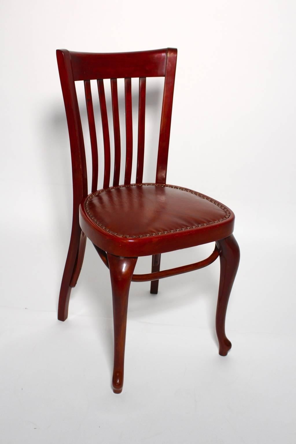 Chaise Vintage By Modèle numéro 519 par Thonet. Adolf Loos a conçu la chaise pour le Café Capua.
Les parties en bois sont polies à la main à la gomme-laque, tandis que le siège est recouvert de cuir brun.
Fabriqué en bois de hêtre teinté et en bois