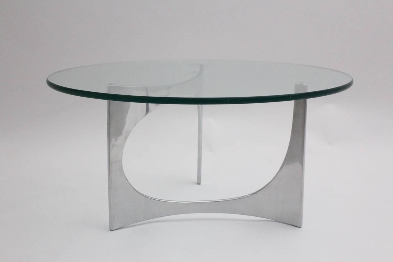 Table basse vintage en métal de l'ère spatiale, conçue par Knut Hesterberg et produite par Bacher Tische Germany vers 1970.
La table basse est composée d'une base en fonte d'aluminium polie et d'un plateau en verre transparent, qui présente quelques
