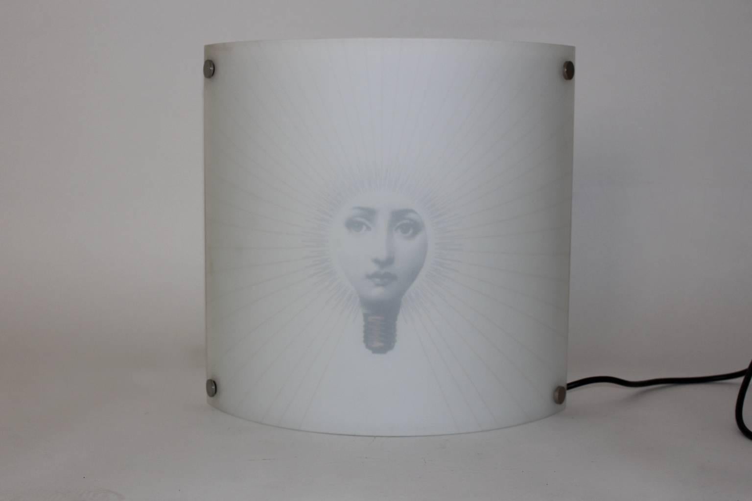 Wall Light printed with the face of Lina Cavalieri designed by Piero Fornasetti and produced by Anton Angeli, Italy 1980s.
You can use various color of bulbs, so it shines through the white glass front.

The surface is made of white etched glass,