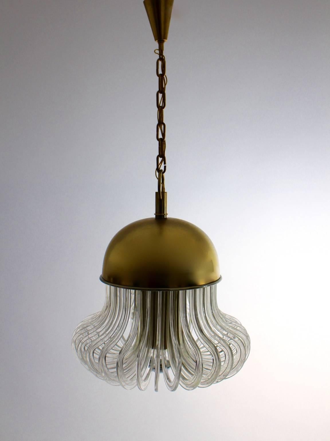 A mid century modern crystal glass vintage chandelier / pendant Mod. Quazar,  which features a brass dome and thirty pieces of curved clear crystal glass sticks. The impressive and beautiful chandelier with a reduced shape was designed by Cari