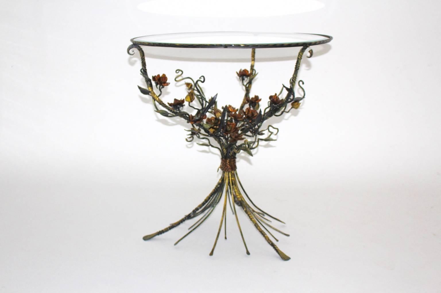 Hollywood regency style metal glass coffee or side table, which is shaped like a bouquet of flowers with a round faceted clear glass top.
The base is made of burnished metal - copper and gold colored.
The glass faceted at the outer edge of the top