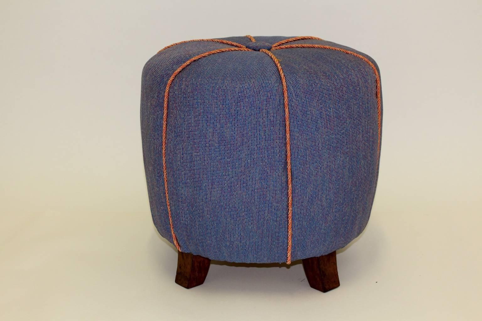 Art Deco vintage blue Pouf or ottoman or stool from blue fabric and beech 1930s Austria.
The stool is reupholstered and covered with a denim blue fabric and pink cords and shows its original shape.
The surface from the beechwood feet are shellac