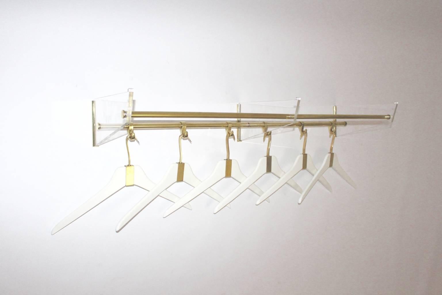 A Mid Century Modern vintage lucite brass coat rack with 6 cloth hangers, which was designed and manufactured Italy 1950s.
Six cloth hangers were made of brass and white lacquered beechwood. 

The brass hardware was carefully cleaned and