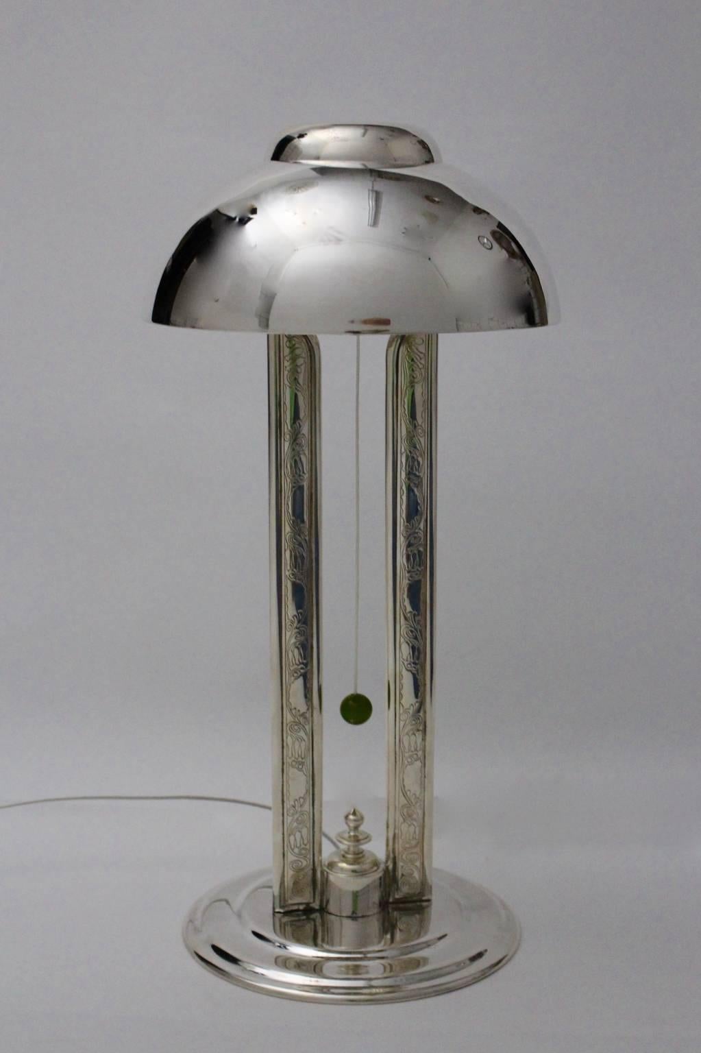 Rara y elegante lámpara de sobremesa hecha a mano, plateada y parcialmente provista de adornos en las franjas de las pilastras.

También la lámpara de sobremesa muestra un interruptor con una bola de baquelita verde.
Además, la lámpara de mesa