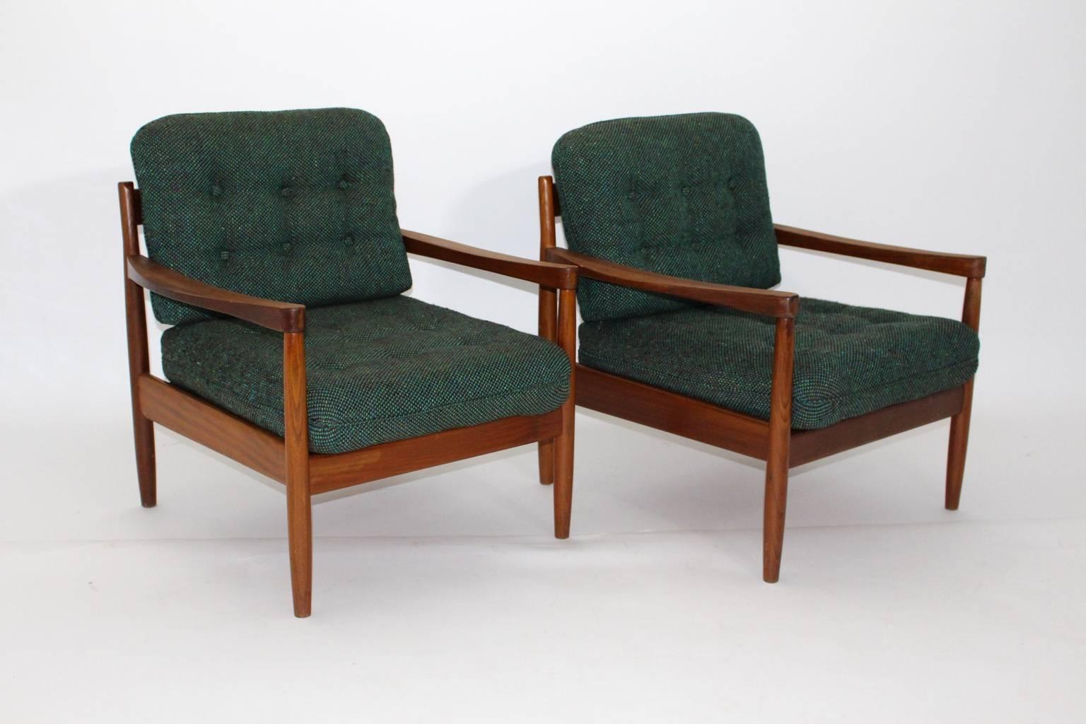 Beautiful sitting room set designed by Grete Jalk, circa 1955, consist of two armchairs and one coffee table, made of teakwood. The cushions are covered with the original textile woolen fabric, which shows a wonderful green-blue color.
Carefully