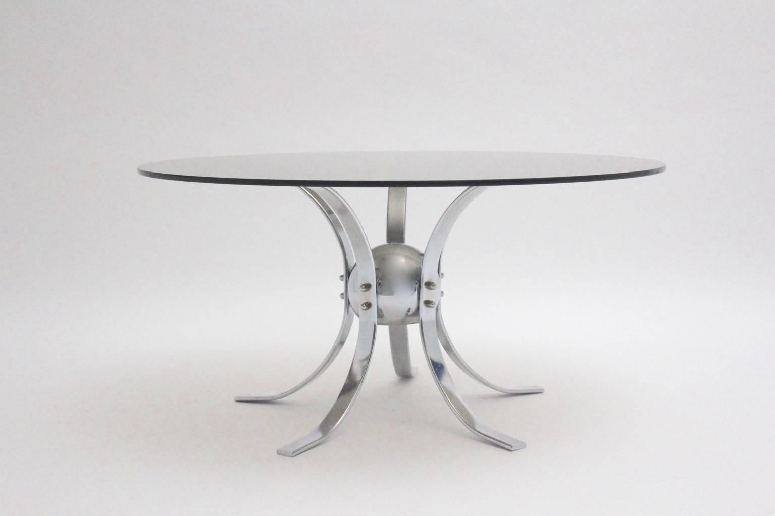 Space Age vintage coffee table from chromed metal and a round glass plate,  which shows a sputnik form.
Designed and manufactured in the 1960s.
Good condition with signs of age and use.
approx. measures:
Base: Diameter 26.77 in (68 cm),
 height