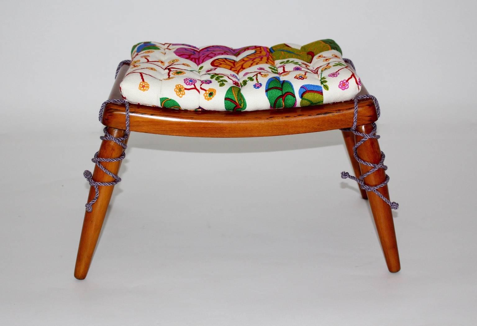 Mid Century Modern vintage stool or ottoman by Anna Lülja Praun circa 1952 from cherry wood. and one loose cushion.
The cushion is newly covered with amazing textile fabric by Josef Frank, now manufactured by Svenskt Tenn and lavender colored cords