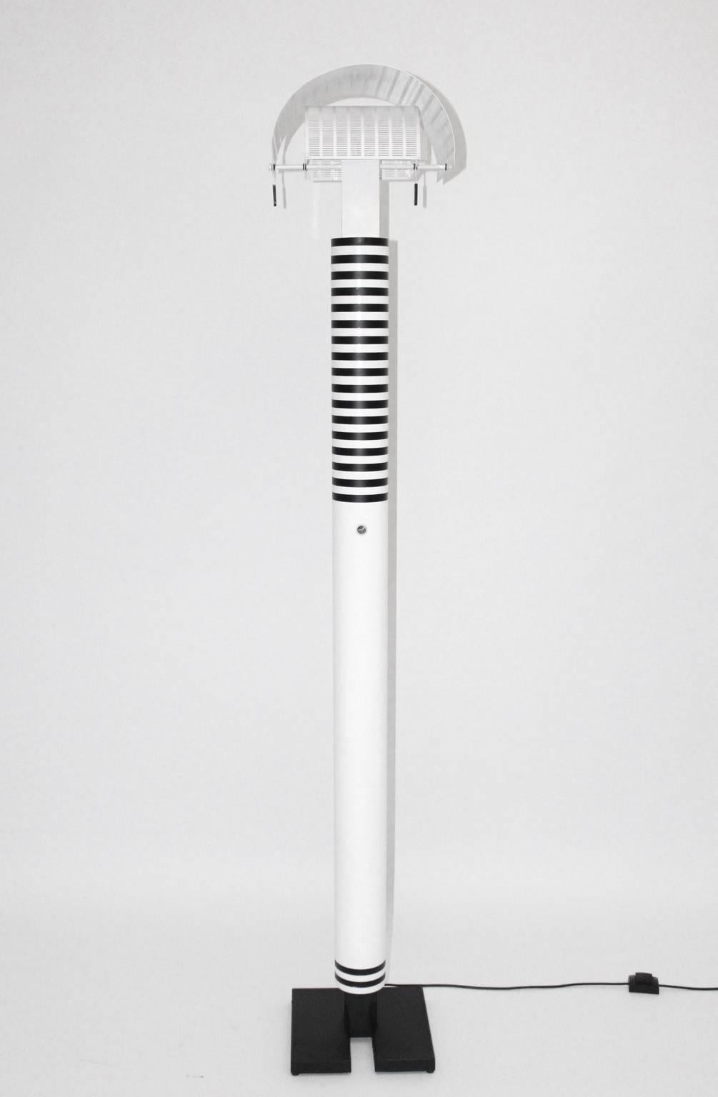 Moderne schwarz-weiße Vintage-Stehleuchte aus lackiertem Metall, entworfen von Mario Botta und ausgeführt von Artemide Italien (beschriftet).
Die Stehleuchte besteht aus weiß und schwarz emailliertem Stahlrohr und emailliertem Aluminium.
Der Zustand