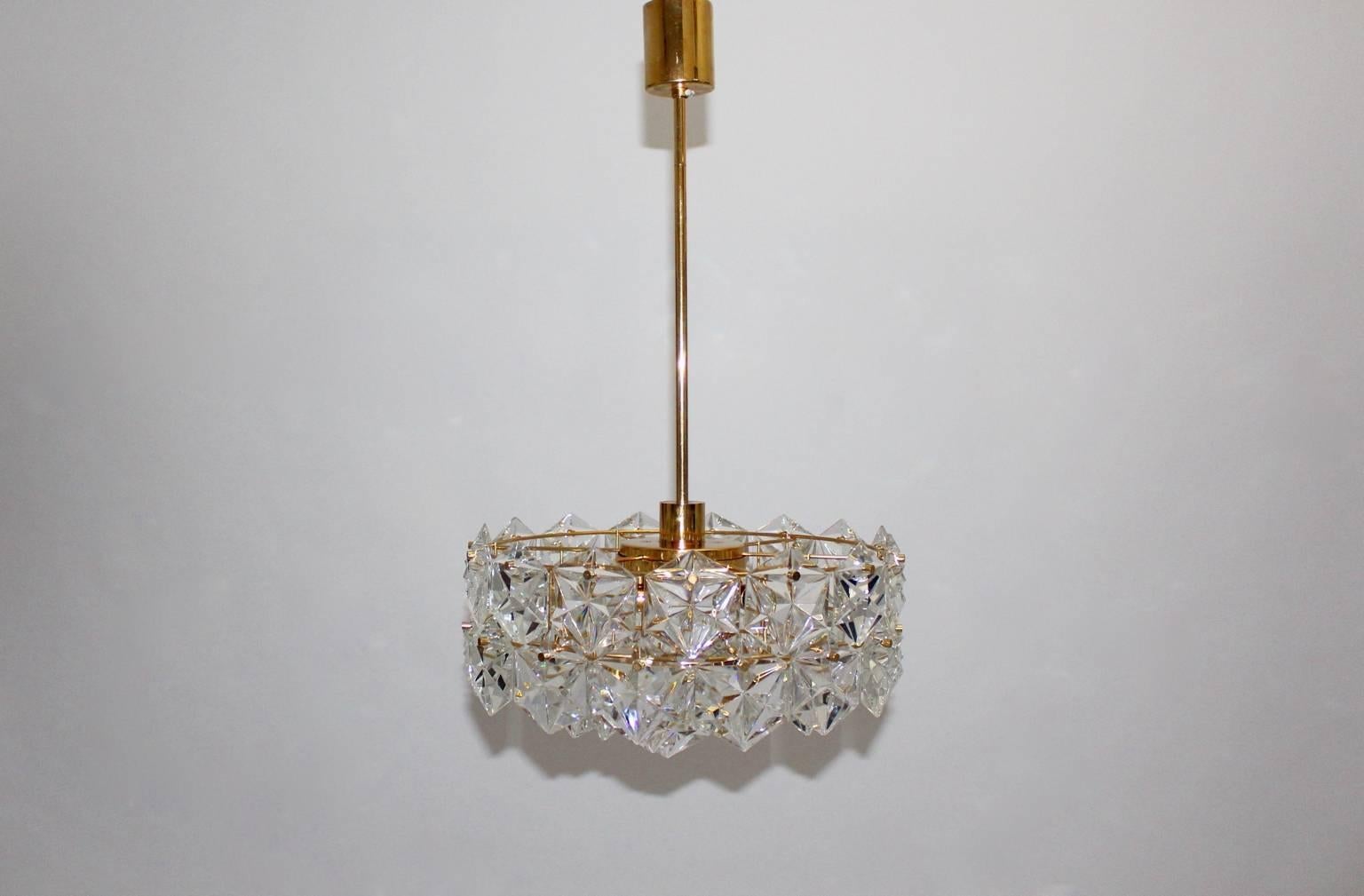 Mid century modern gold plated vintage chandelier labeled by Kinkeldey, Germany,  which shows 4 tiers with gilt frame and 46 facetted hexagonal crystals.
Fittings for six sockets E 14 and one fitting for a socket E 27.
The chandelier is in very good