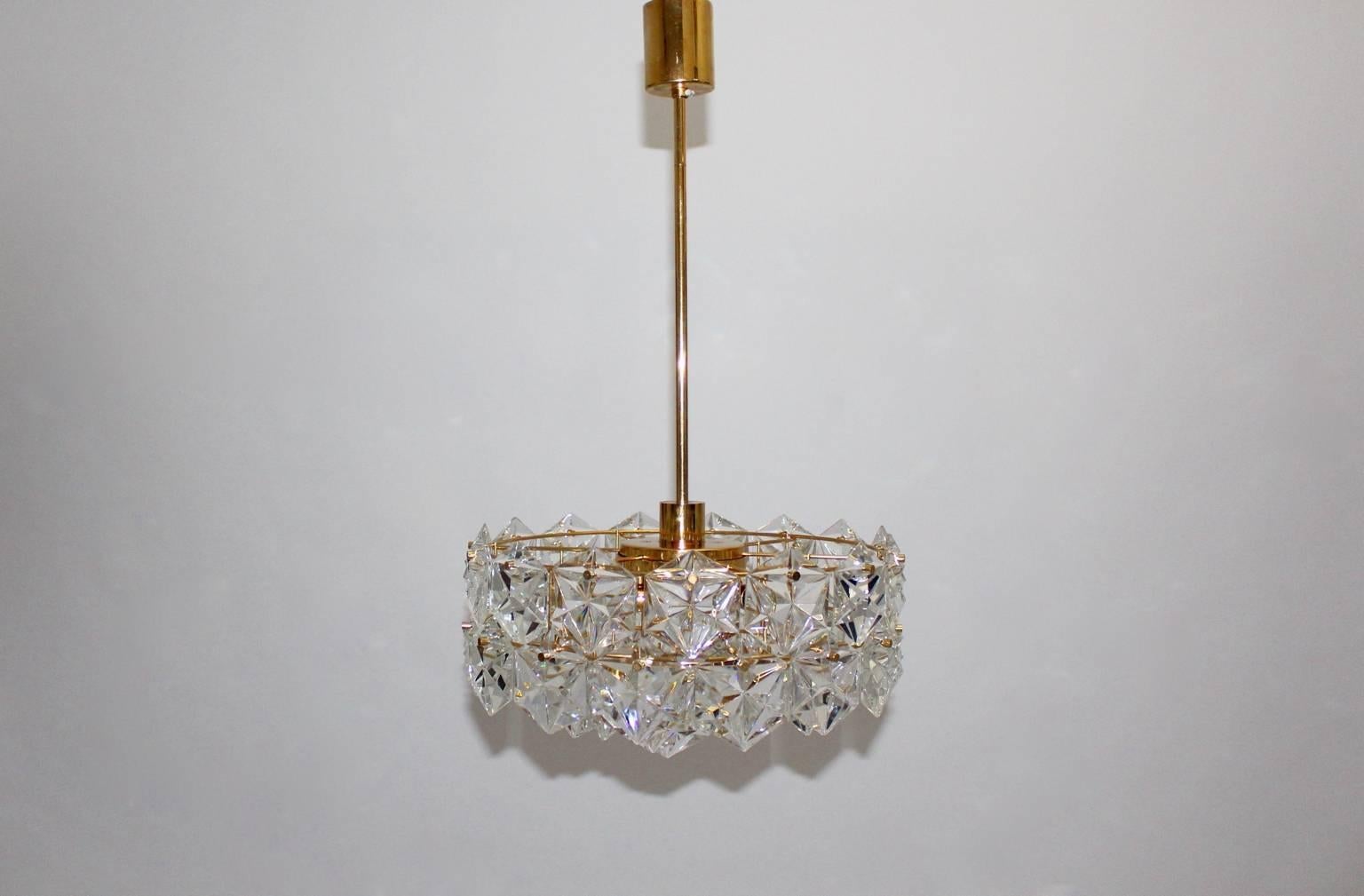 Mid century modern gold plated vintage chandelier labeled by Kinkeldey, Germany,  which shows 4 tiers with gilt frame and 46 facetted hexagonal crystals.
Fittings for six sockets E 14 and one fitting for a socket E 27.
The chandelier is in good
