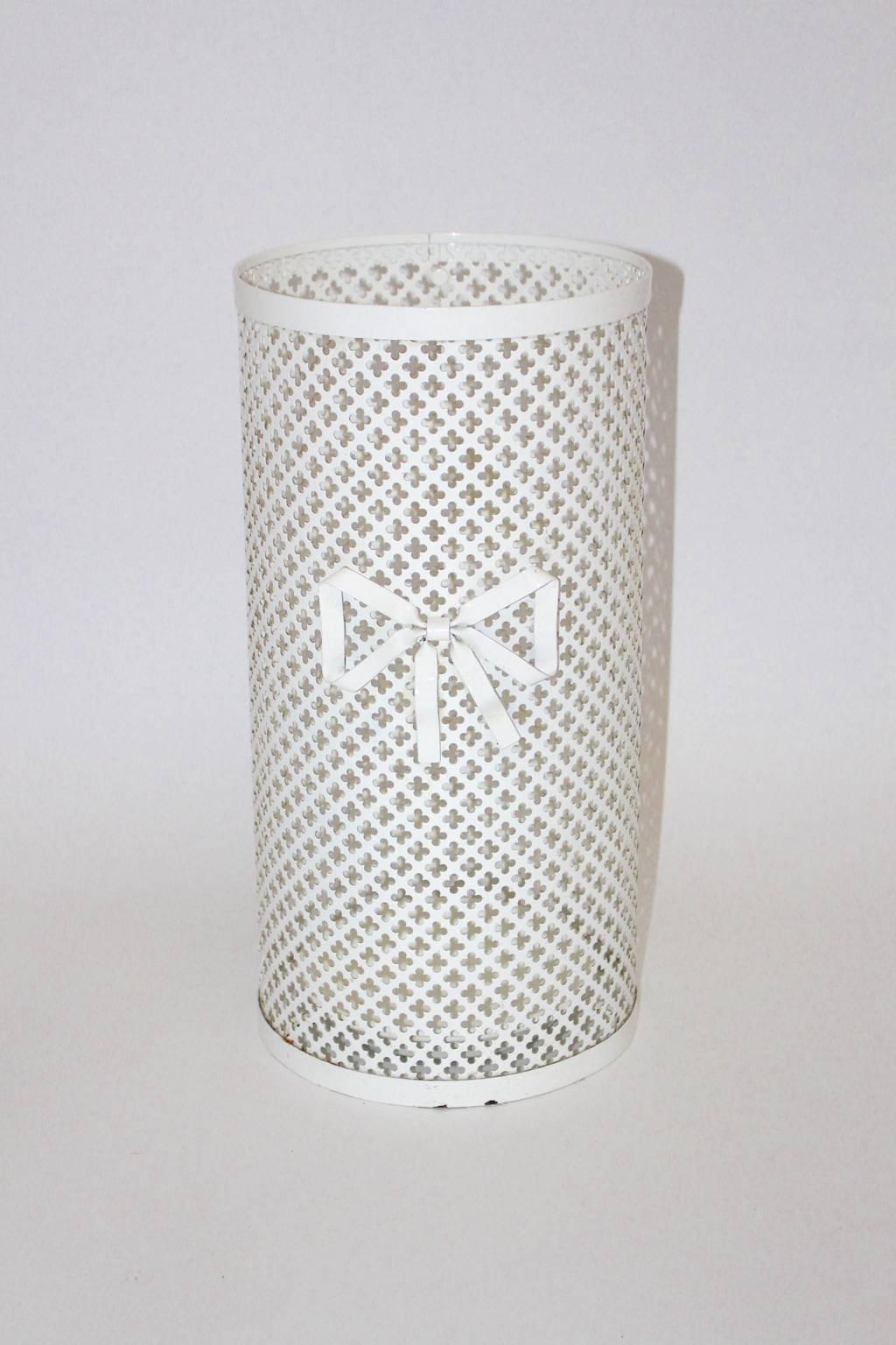 Elegant white enameled perforated umbrella stand made of metal with bow tie and white dipping pan.
To use as an umbrella stand and also as a waste basket.
Designed by Mathieu Matégot for Atelier Matégot.

This umbrella stand is in very good