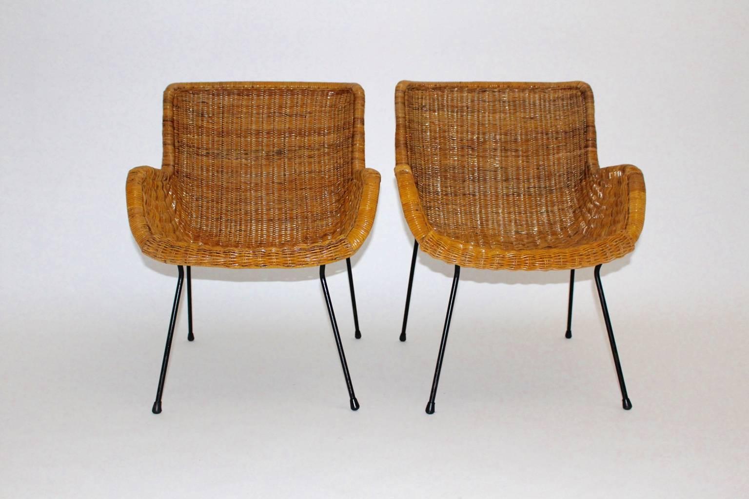 These charming and comfortable pair of wicker armchairs shows a base with black lacquered tube steel and rubber feet.
Also the honey brown colored seat shell was made of wicker work.

These wicker armchairs are in very good vintage condition and