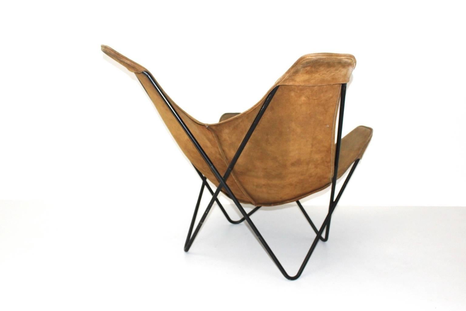 Fabulous Butterfly Chair ; designed by Jorge Ferrari-Hardoy, Juan Kurchann & Antonio Bonet, 1938 and produced by Knoll Associates New York, 1947-1975.

This presented chair consists of a black enameled tabular steel frame with a brown suede leather
