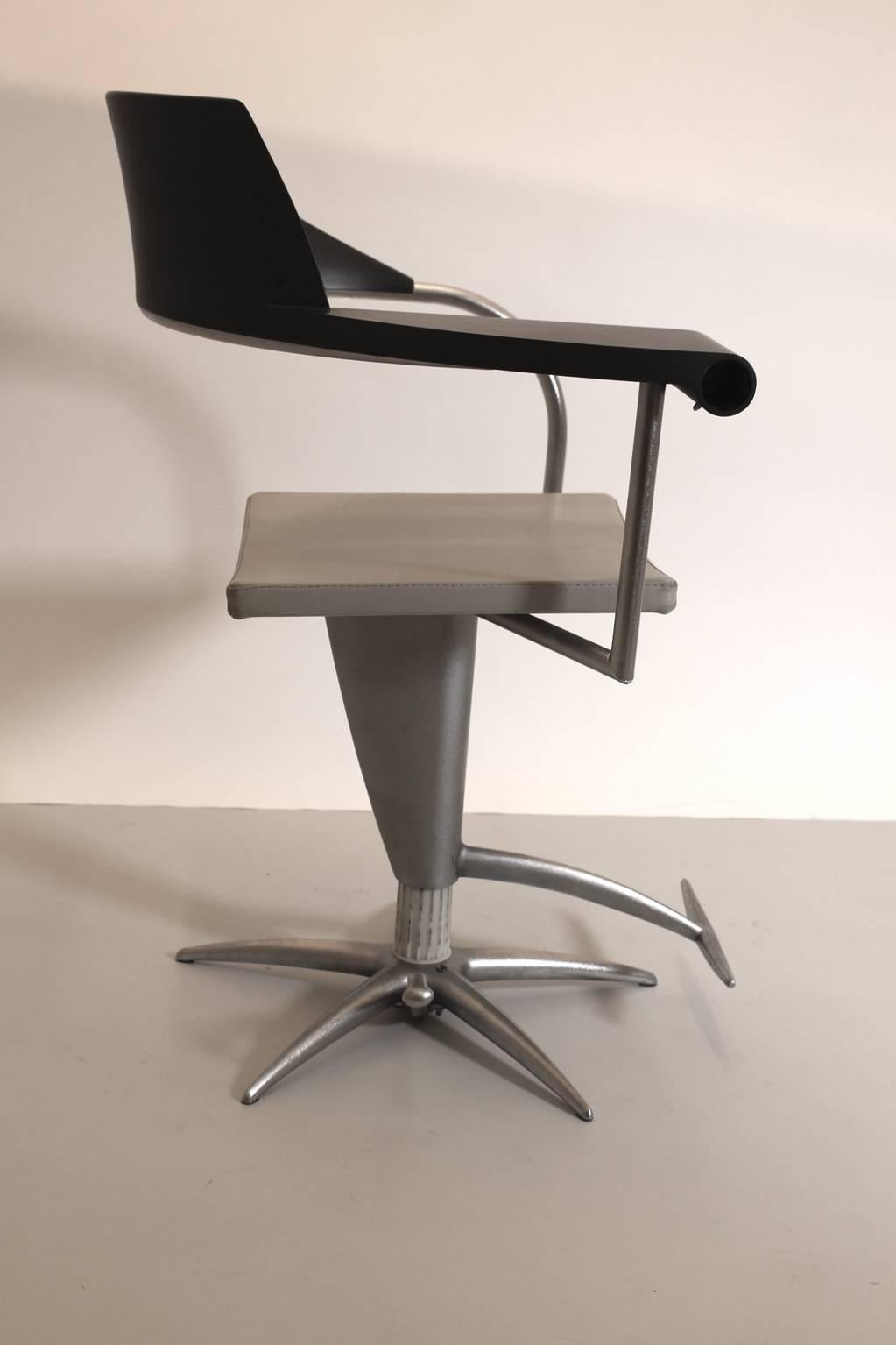 Fauteuil ou chaise de bureau vintage postmoderne en plastique, aluminium et acier en noir et argent par Philippe Starck 1980. 
Les accoudoirs incurvés se fondent dans le siège et on y trouve un cendrier caché.
Ce fauteuil était probablement utilisé