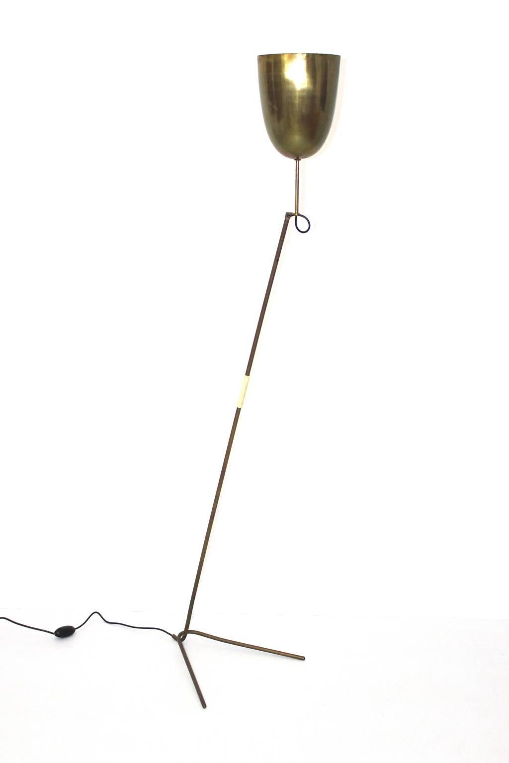 Brass floor lamp with a splayfoot designed and made in 1950s in Austria.
On/off switch. 
One socket Edison 27.

The floor lamp shows in the middle of the stem a decorative plastic string handle.

The floor lamp is in very good condition with nice