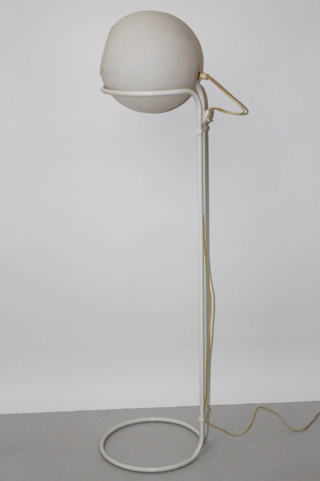 The floor lamp features a frame made of tube steel and white lacquered and shows an adjustable milk glass ball shade.

The milk-glass shade is removable and so you are able to lead the shine in the requested direction.
There is one socket Edison
