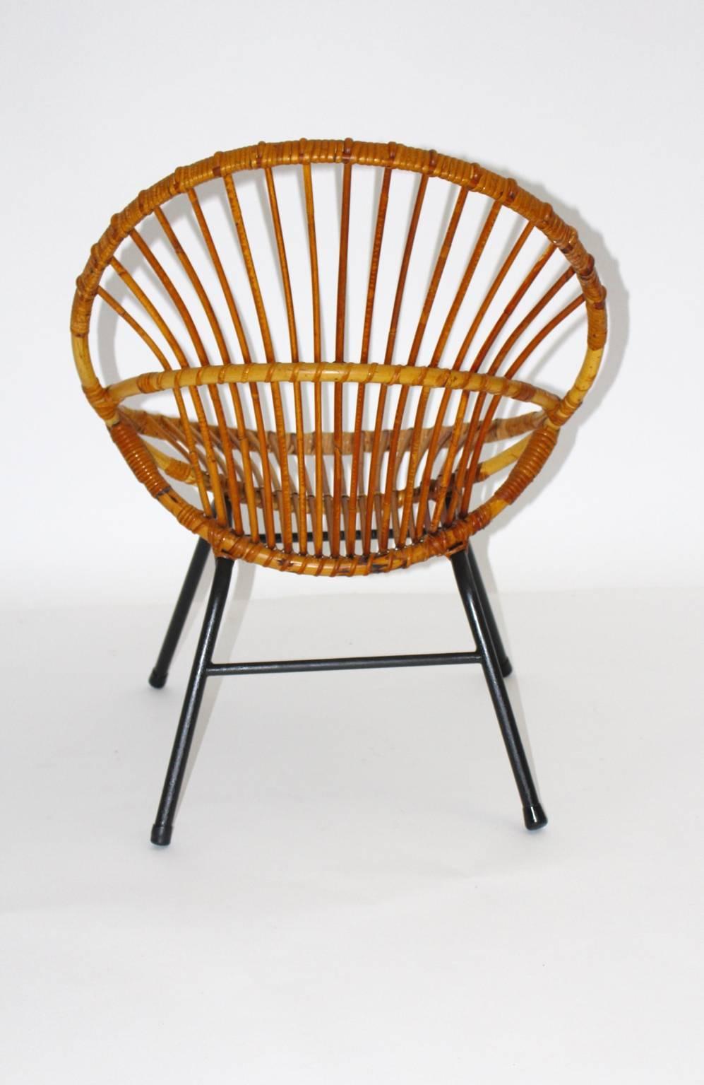 Mid Century Modern Vintage Rattanstuhl von Rohe Noordwolde, Niederlande, 1960er Jahre.
Die Sitzschale wurde aus Rattan gefertigt und das Stahlrohrgestell schwarz lackiert.
Die Metallfüße sind mit Gummipuffern versehen.
Der Sitz ist in einem guten