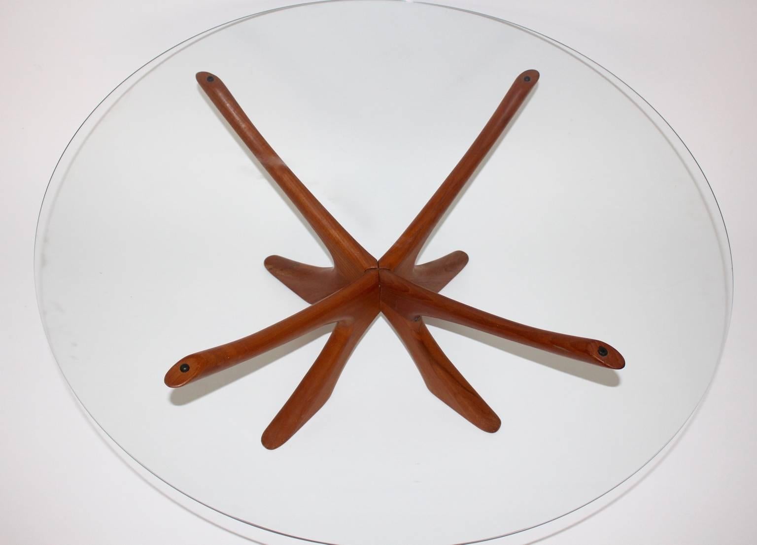 Mid century modern teak coffee table in sculptural form designed by Illum Wikkelso in Denmark, circa 1960.
The table base was made out of teak wood  and topped with a clear glass plate.
The vintage condition is very good.
approx. measures:
Diameter: