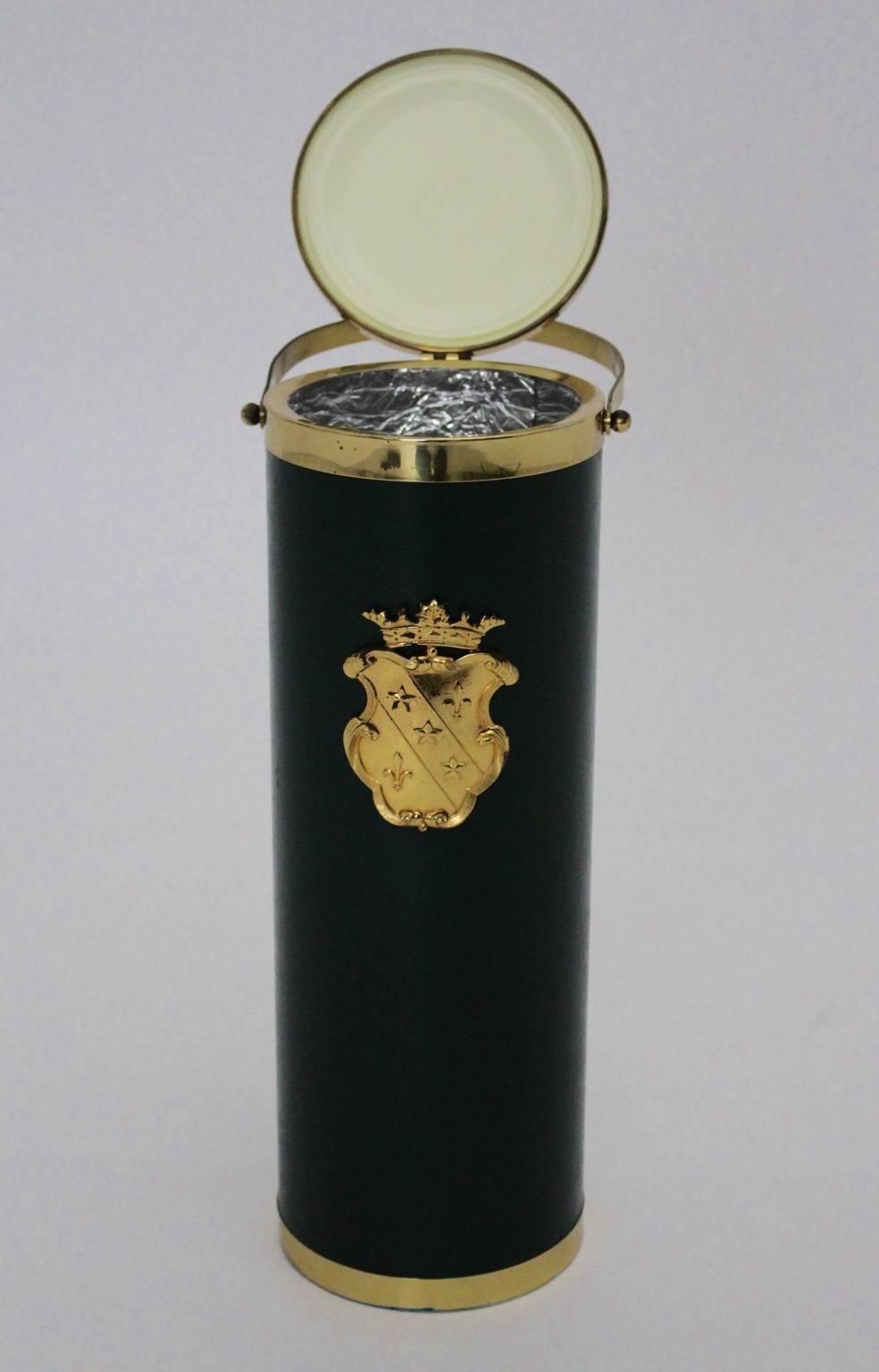 The wine cooler was made of a brass plated metal base and also made of waxed green faux leather.
The front side is decorated with a golden crown.
The wine cooler was fitted with a silver foil covering.
The vintage condition is very good .
All