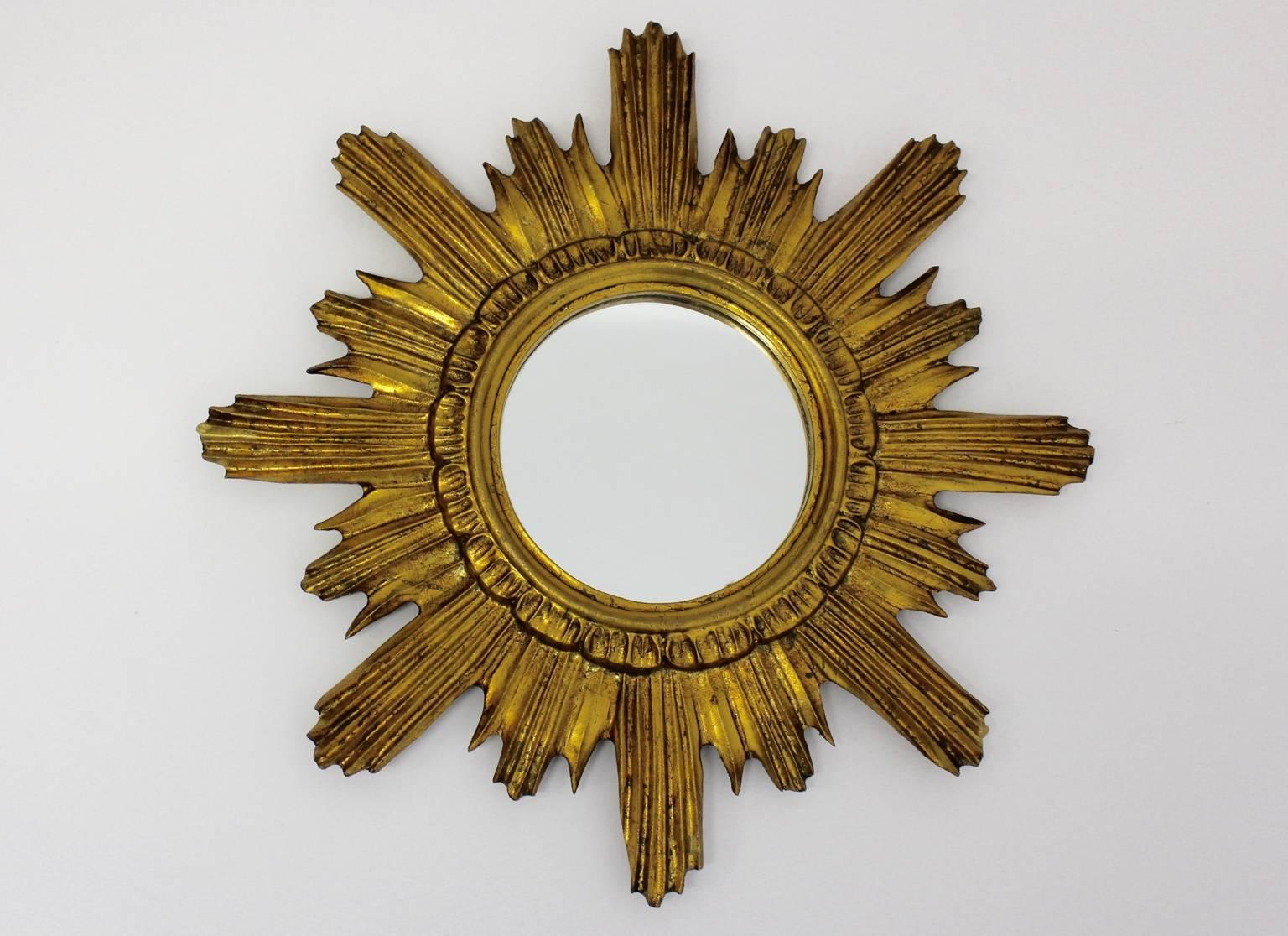 The gilded sunburst mirror was designed and manufactured in Italy, 1960s. The carved and gilded sunbursts are in excellent original condition, as well the original mirror glass.

The diameter of the mirror glass is 5.91 in.
The diameter of the